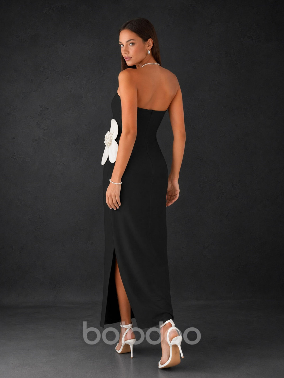 BOLODOO Black Strapless Oversized 3D White Flower Appliqué Side Slit Bodycon Midi Dress - Front Full Length Standing with Pearl Bag View | BOLODOO watermark