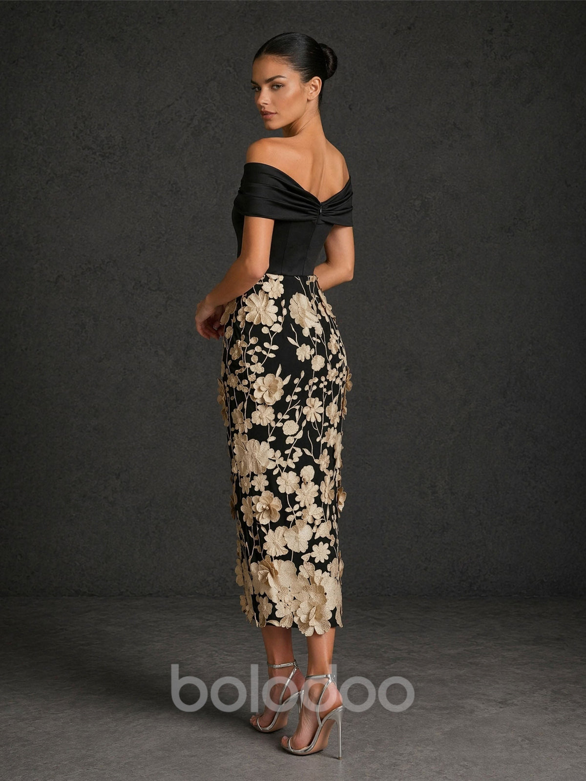 BOLODOO BD0422 black and champagne gold off-shoulder twisted V-neck 3D floral appliqué tea length dress – back view showing open back with twisted knot detail and champagne gold floral embroidered skirt | BOLODOO watermark