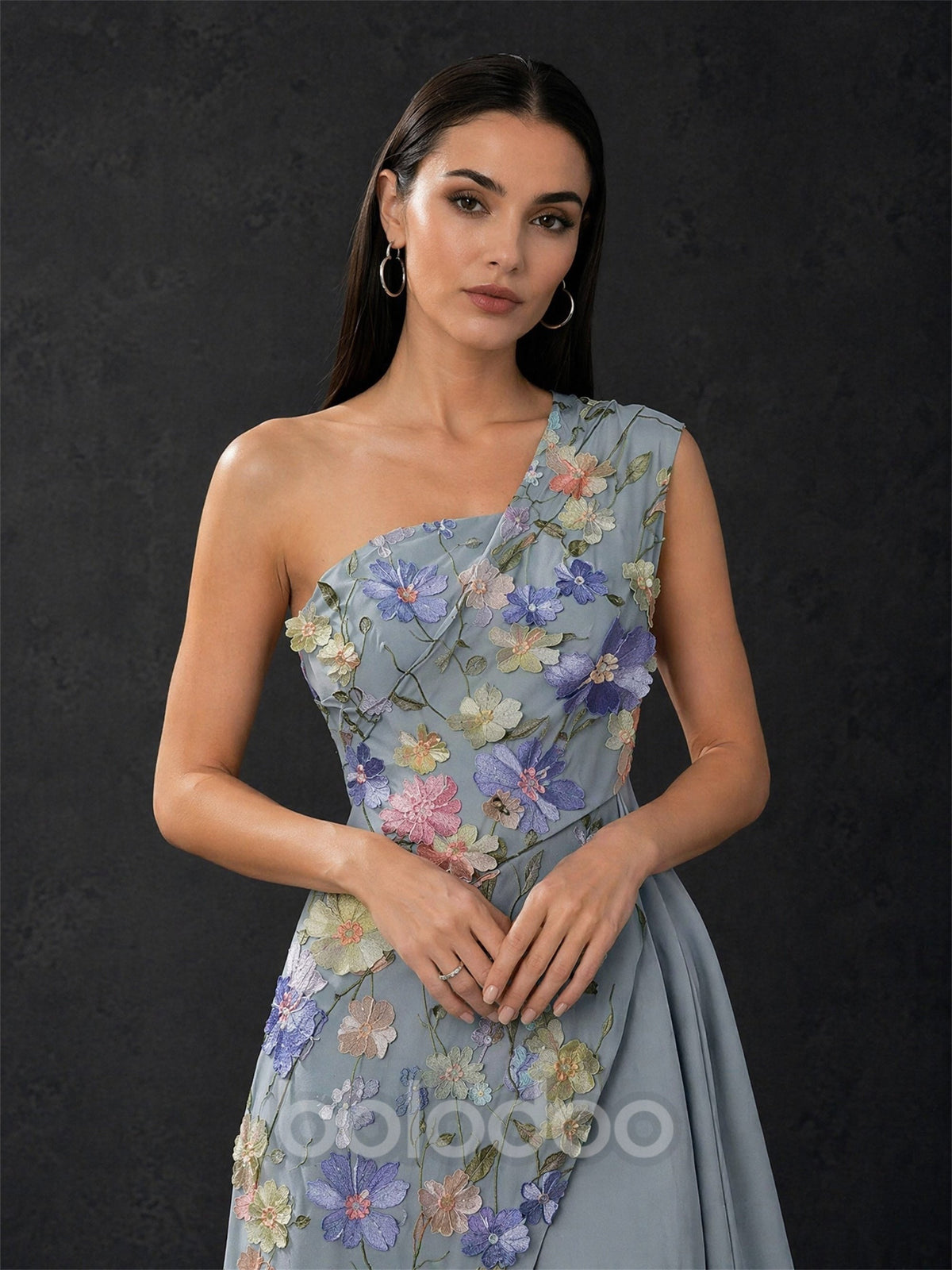 BOLODOO dusty blue one-shoulder gown close-up front view showing draped bodice and 3D lavender blush floral appliqué tulle panel detail | BOLODOO watermark