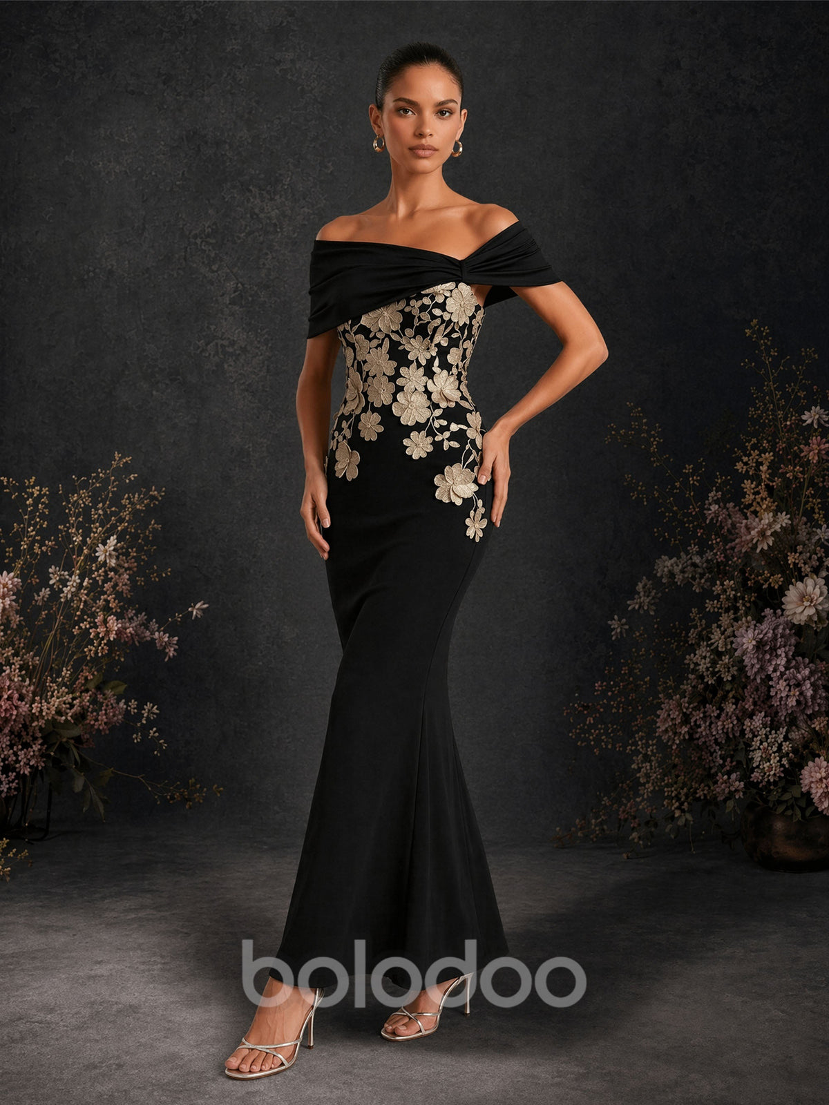 BOLODOO BD0420 black and gold off-shoulder gold floral appliqué mermaid gown – back view showing open back with twisted off-shoulder neckline and gold floral cascade | BOLODOO watermark