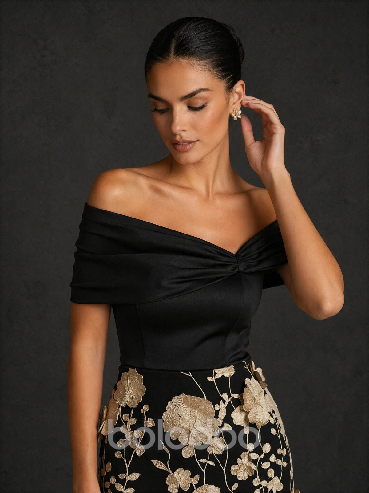 BOLODOO BD0422 black and champagne gold off-shoulder twisted V-neck cap sleeve 3D floral appliqué tea length dress – close-up of twisted off-shoulder neckline and champagne gold 3D floral appliqué skirt detail | BOLODOO watermark