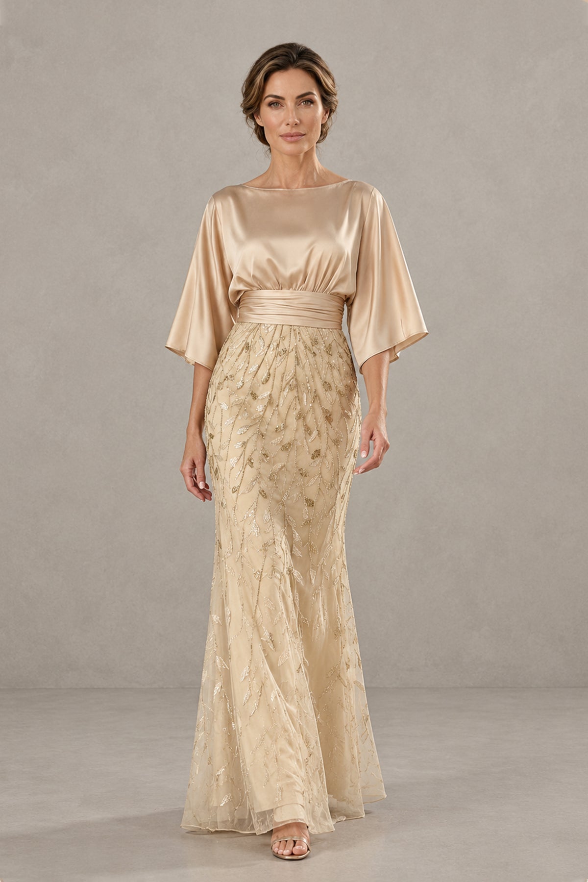 Three-quarter view of champagne gold mother of the groom dress with pleated satin waist