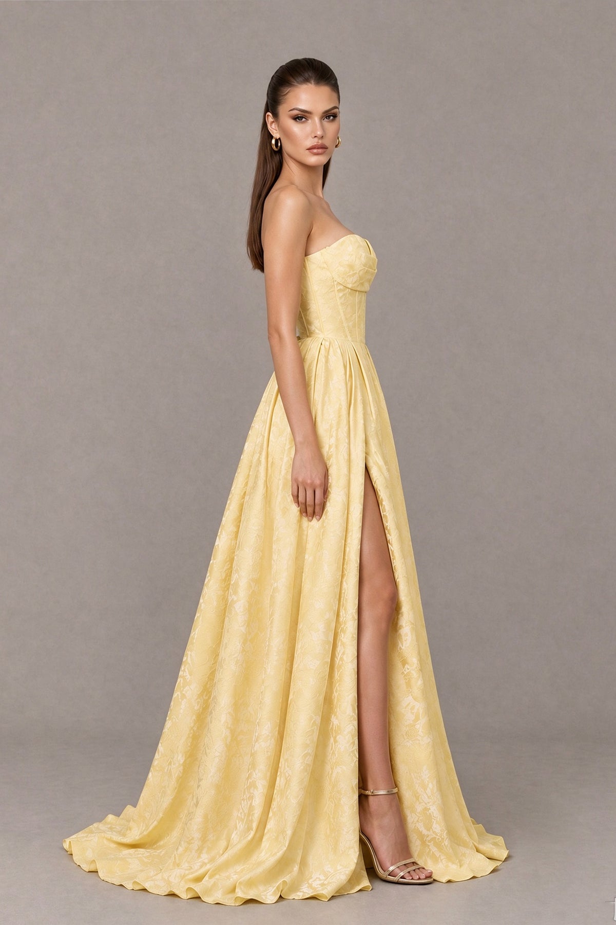 Side view of BOLODOO yellow strapless corset evening gown showing high slit and floor-length A-line skirt