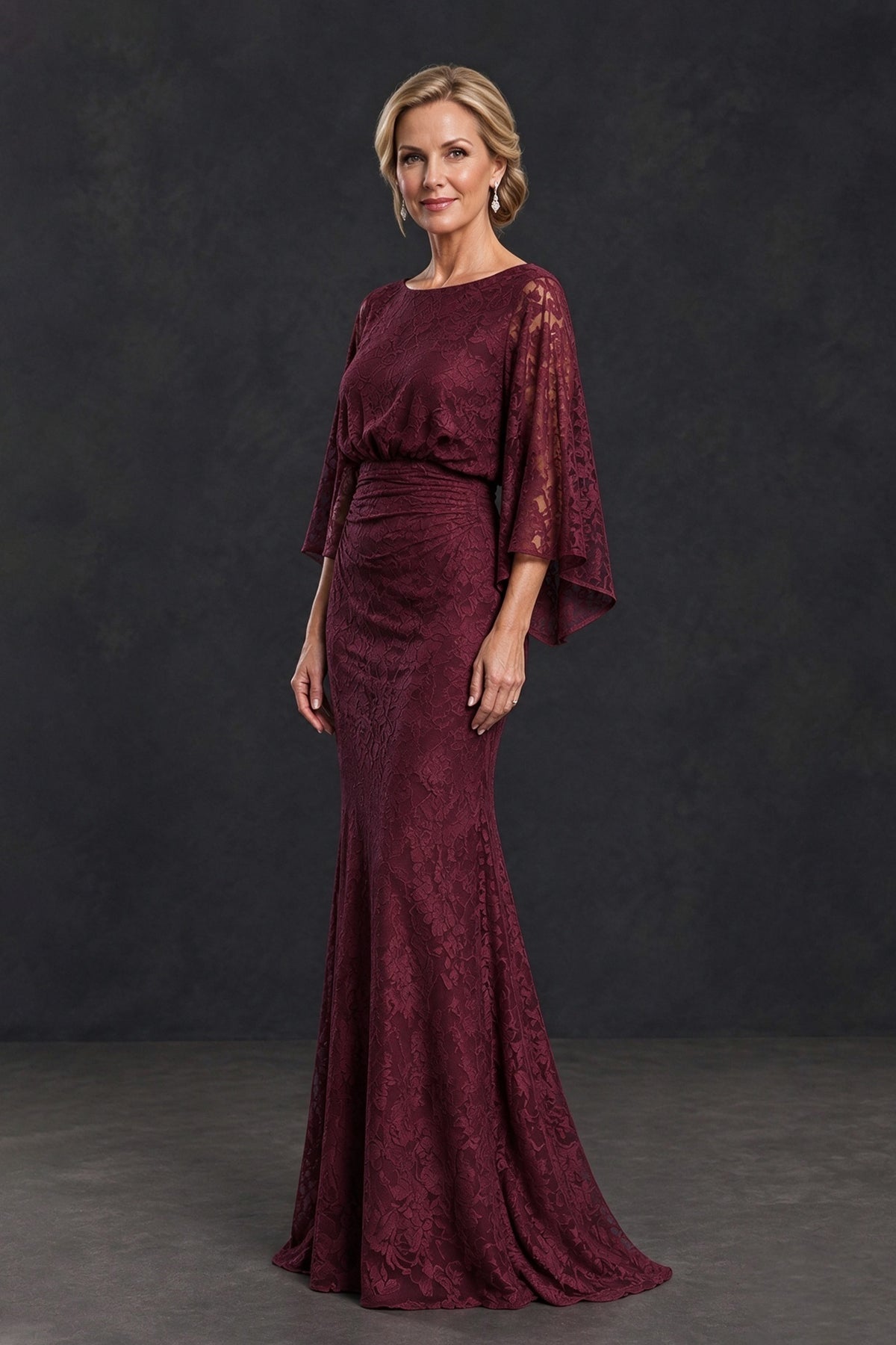 Side-front view of BOLODOO burgundy lace gown showing ruched waist and flared floor-length skirt