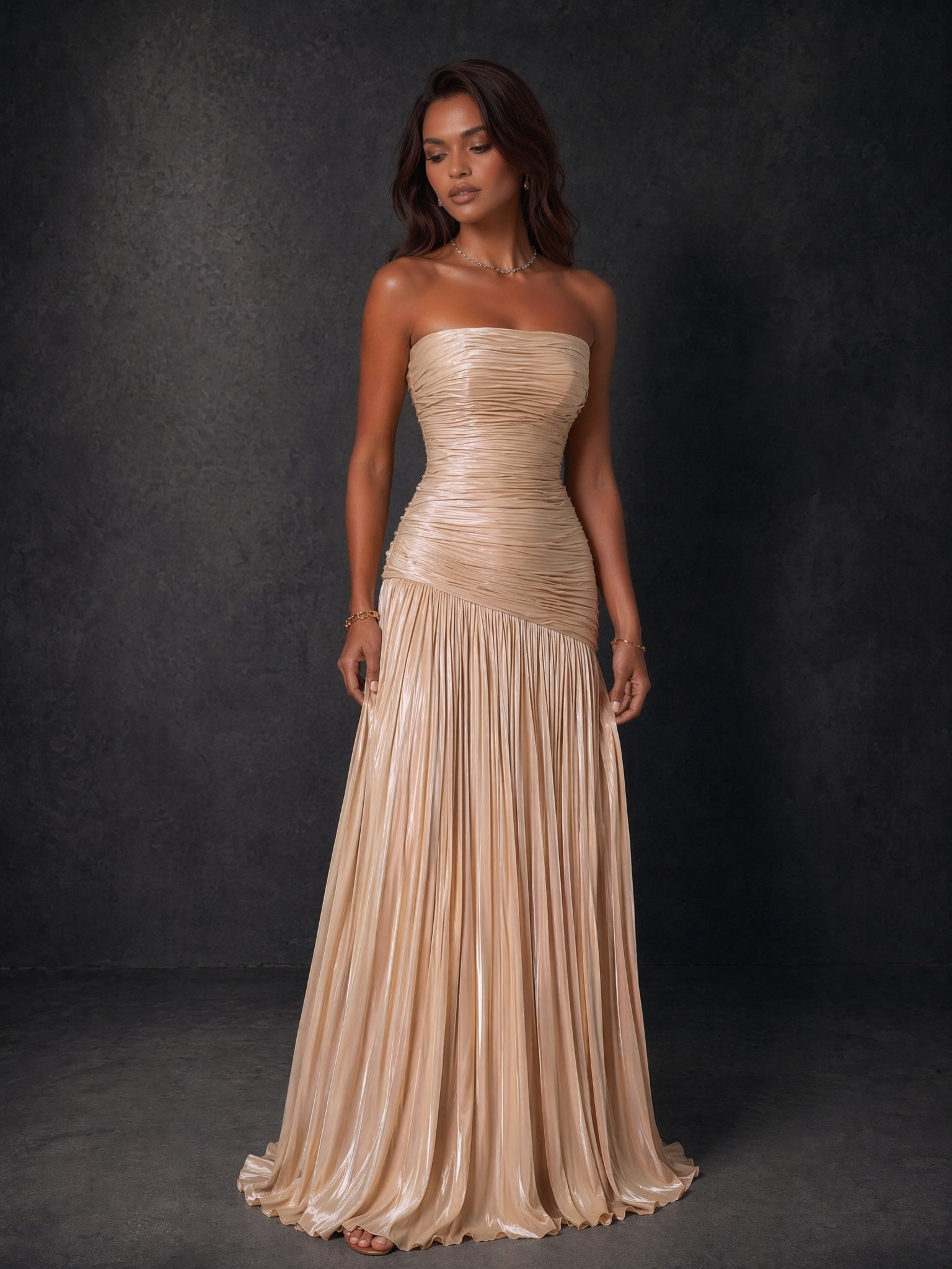 BOLODOO champagne gold metallic ruched strapless pleated A-line backless maxi dress - front view walking pose