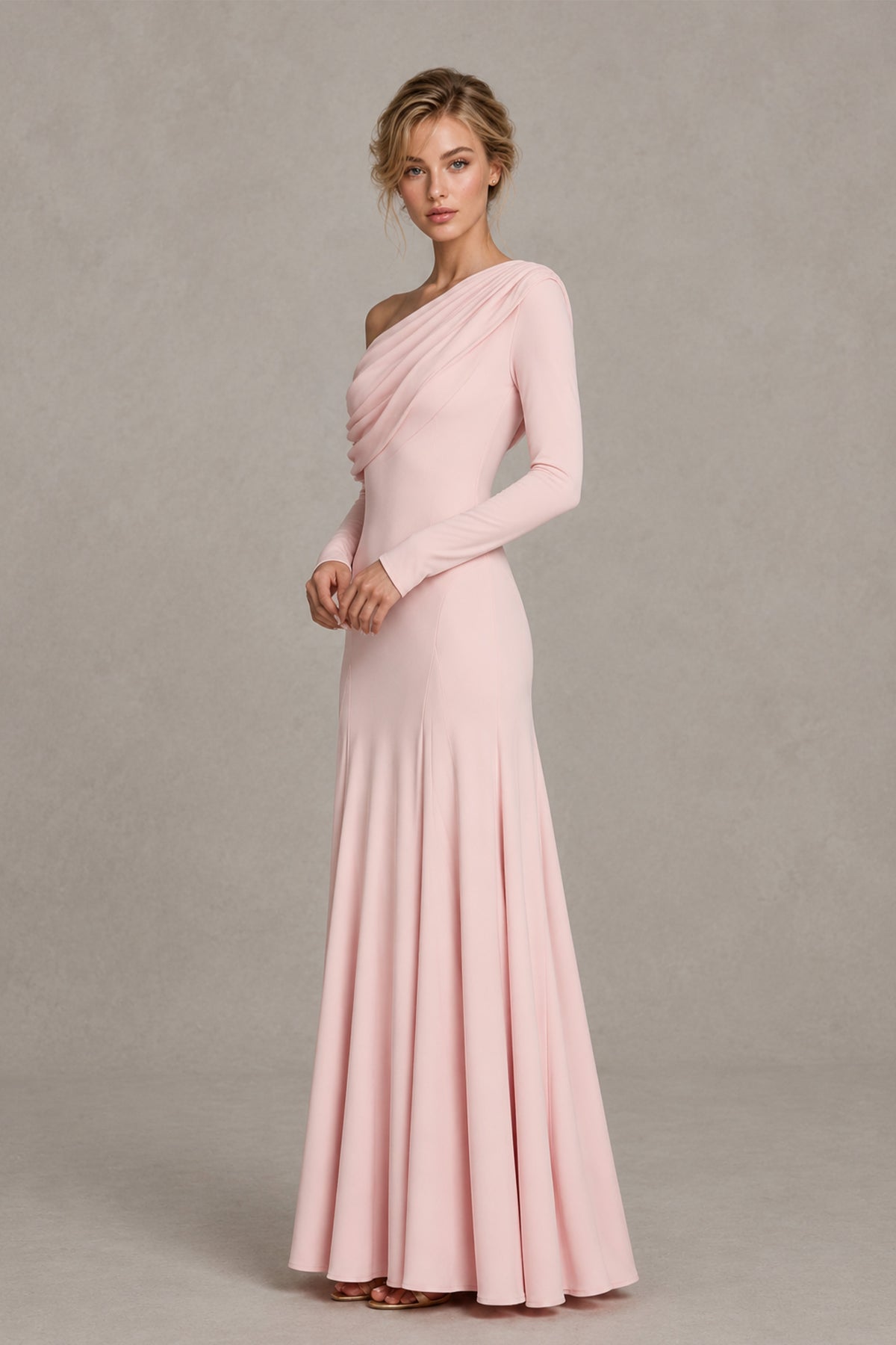 BOLODOO blush pink floor-length gown showing draped neckline and fitted silhouette, angled front view