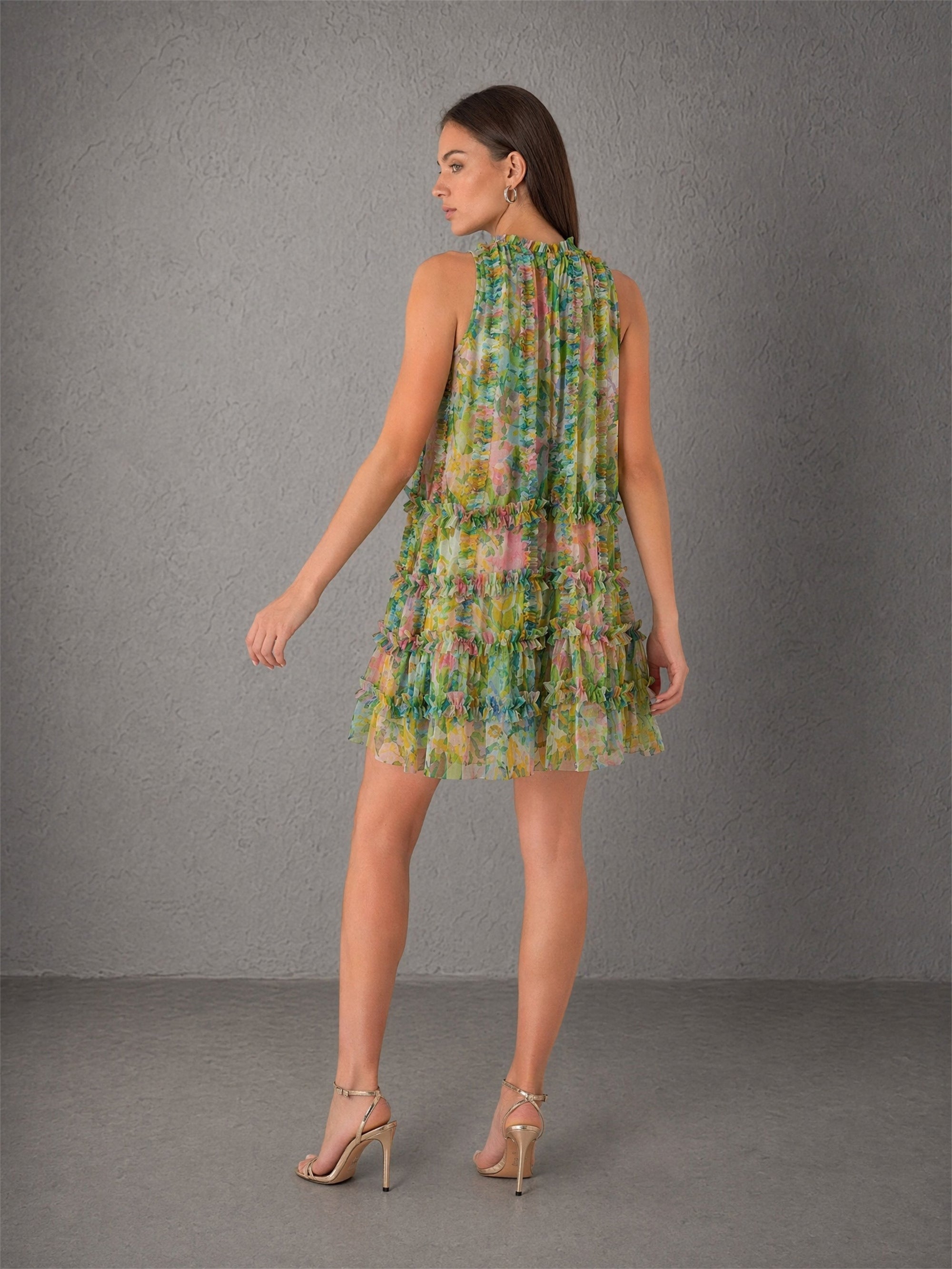 BOLODOO green floral chiffon ruffle mini dress - three-quarter front view with hand raised showing lightweight chiffon movement