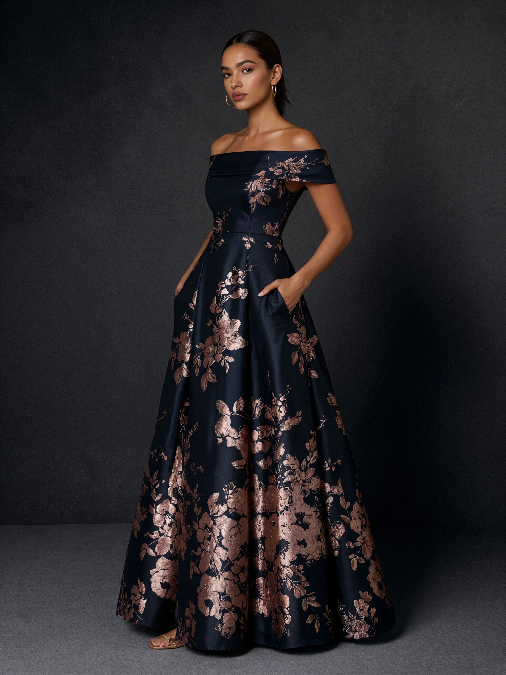 BOLODOO navy blue jacquard ball gown - three-quarter front view with hand on hip and gold clutch showing brocade gradient detail