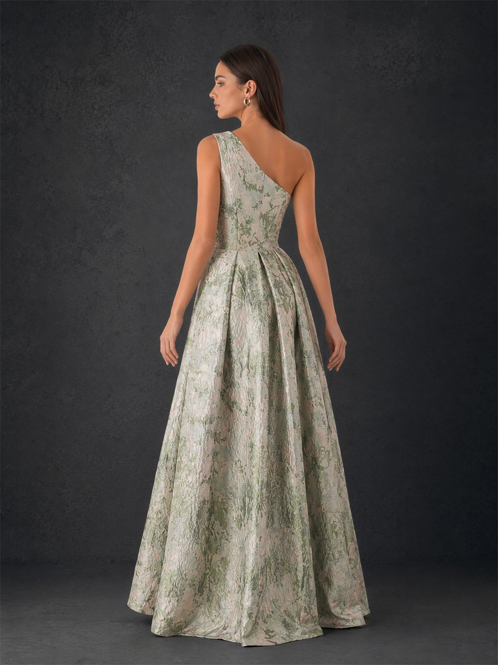 BOLODOO sage green metallic jacquard one-shoulder gown - front close-up showing side slit detail and box pleat skirt
