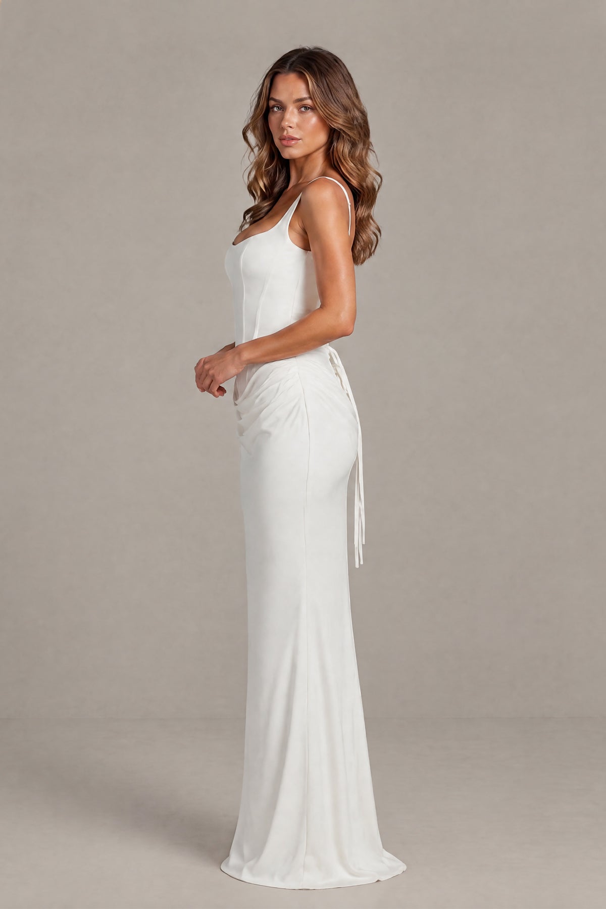Side view showing the fitted floor-length silhouette of the white bridal gown