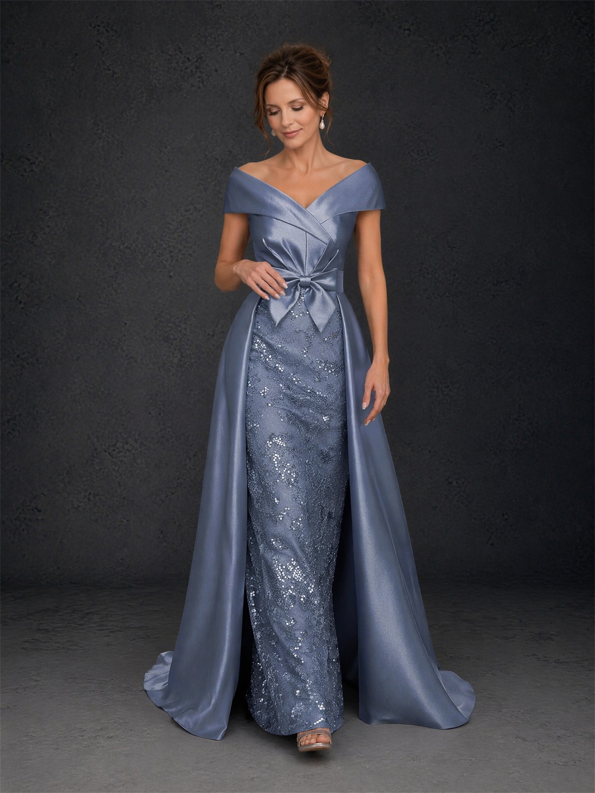 BOLODOO steel blue off-shoulder mermaid gown - front view with hand on skirt showing off-shoulder V-neckline, bow detail and sequin lace underskirt