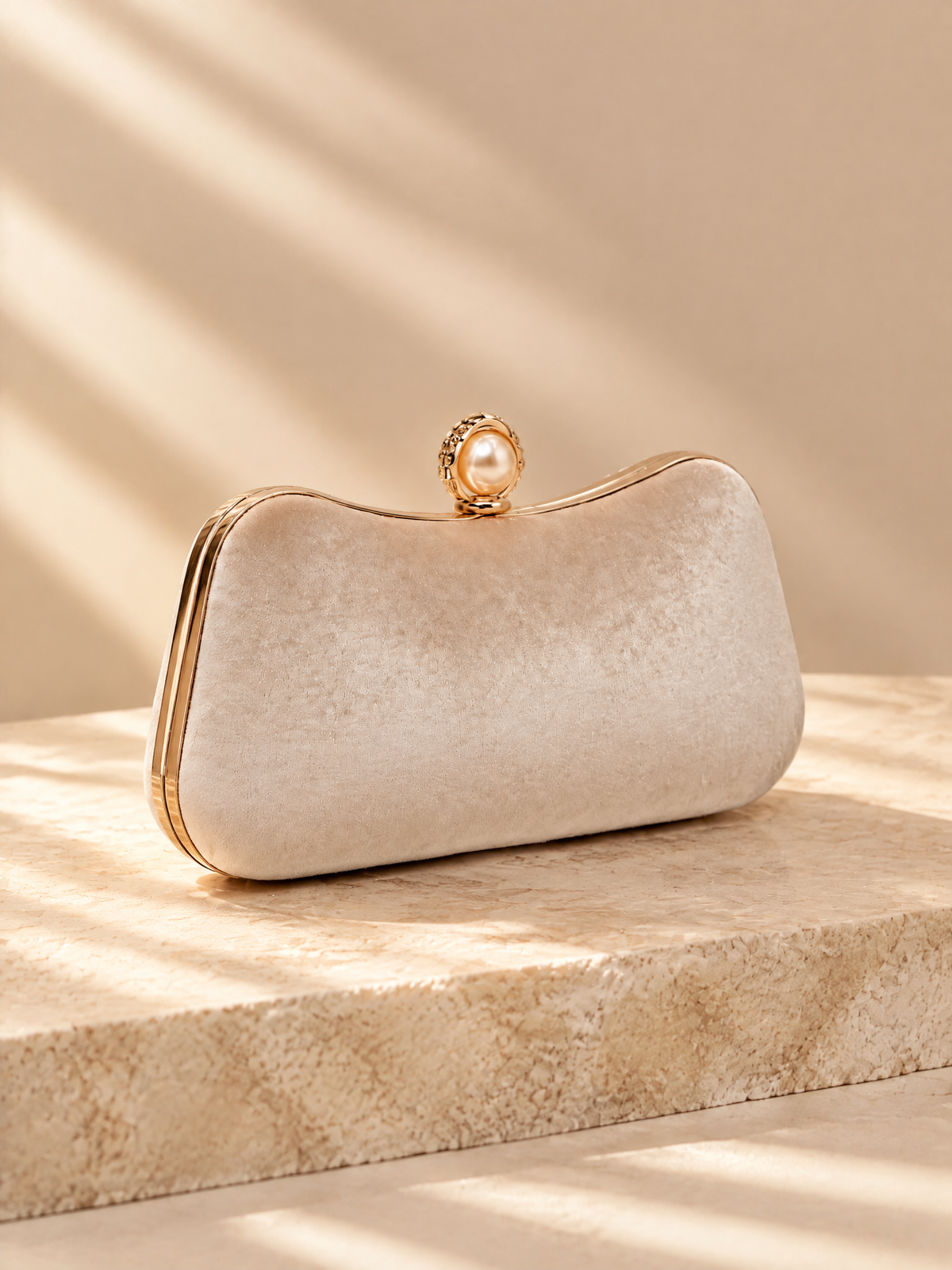 BOLODOO ivory structured clutch, angled view showing rounded corners and gold-tone frame