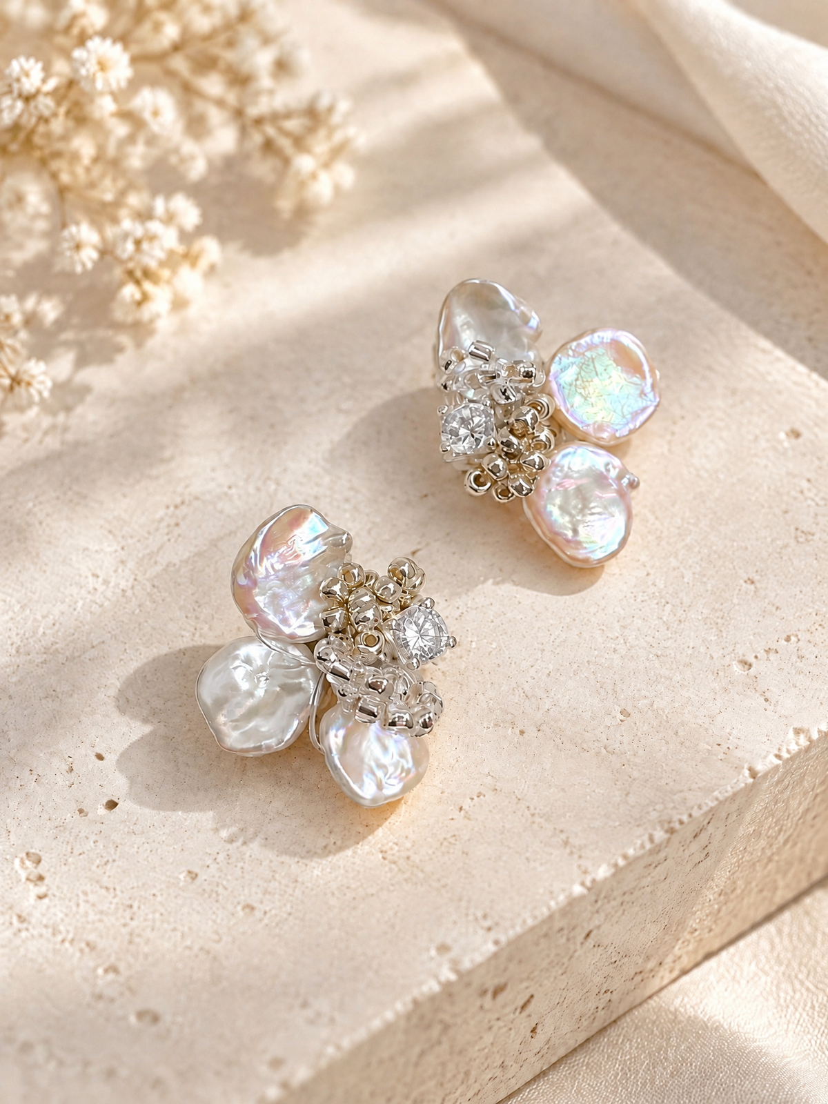 Angled detail view of BOLODOO iridescent floral earrings with curled metallic accents