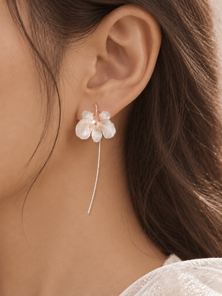 Close view of BOLODOO ivory flower drop earrings showing luminous petals and slender gold-tone drops