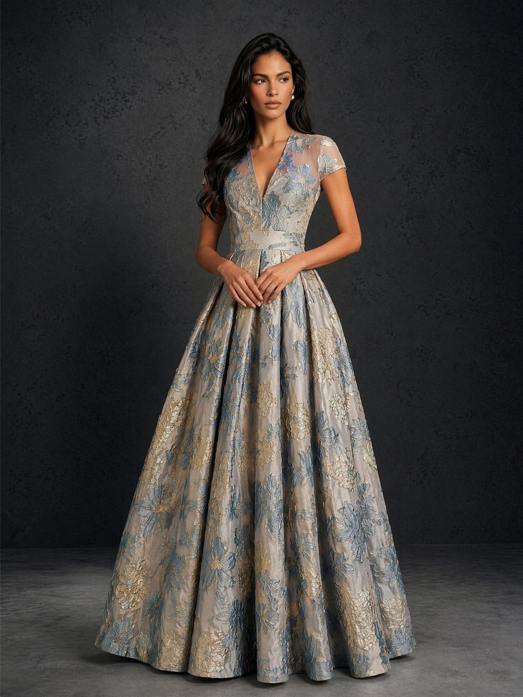 BOLODOO silver blue gold floral jacquard sheer V-illusion cap sleeve A-line ball gown with satin waistband – front full length hands clasped view
