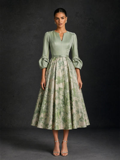 BOLODOO sage green satin V-notch 3/4 puff sleeve champagne floral jacquard A-line tea length dress with slim belt – front full length dynamic walking view