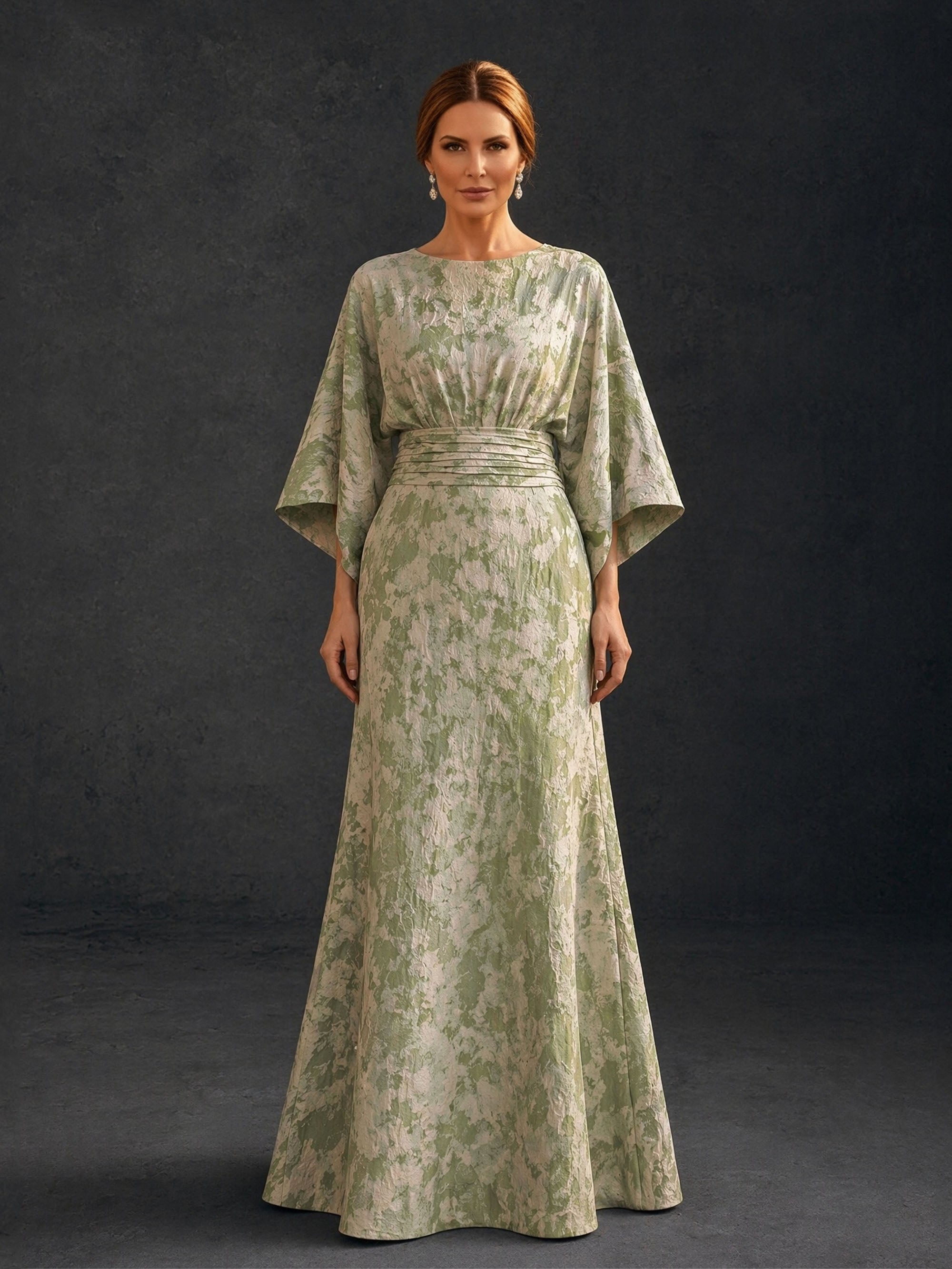 BOLODOO sage green floral brocade bateau neck batwing kimono sleeve gown close-up front view showing neckline wide batwing sleeve and ruched waistband detail
