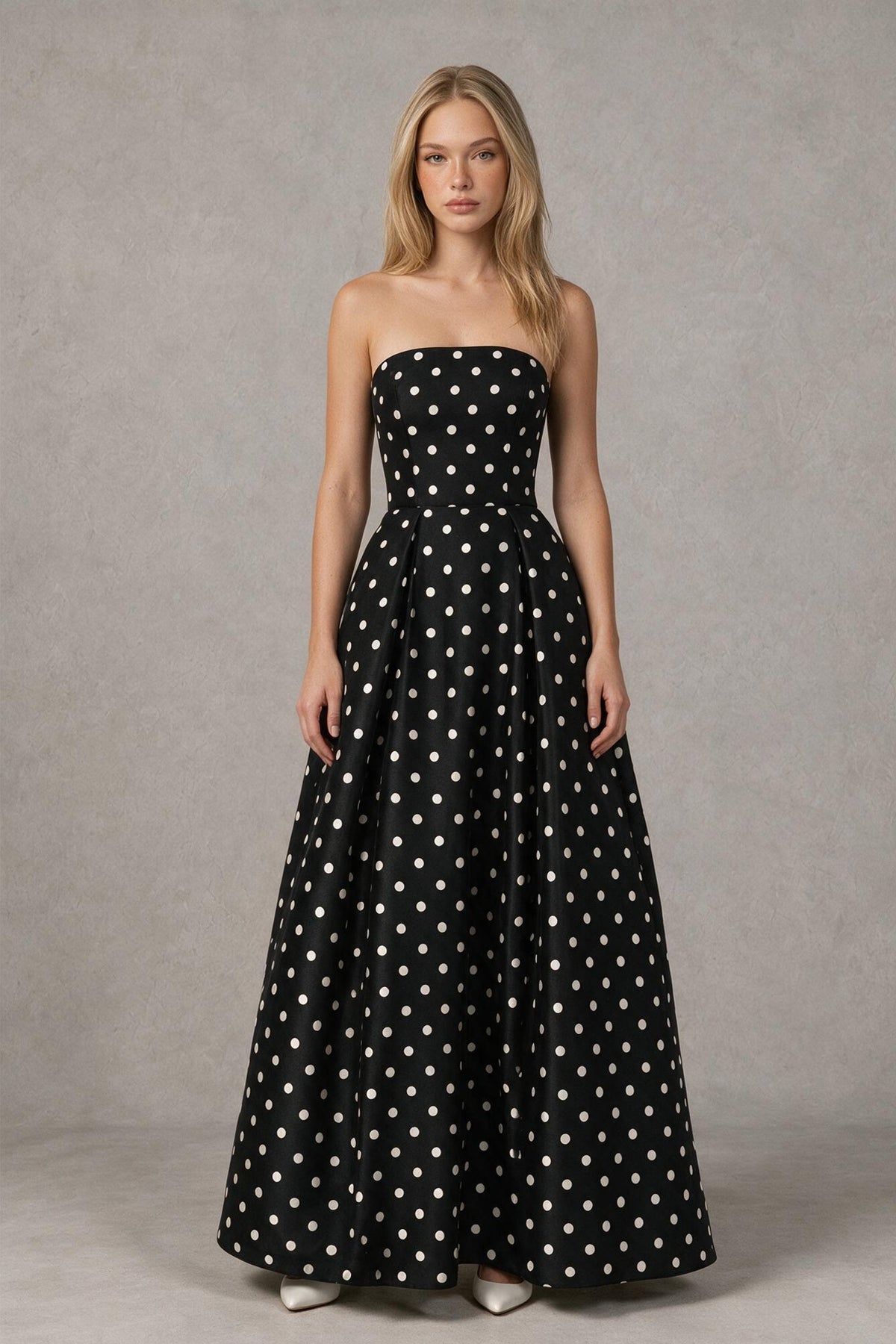 Three-quarter view of black polka dot formal maxi dress with full skirt and side pockets