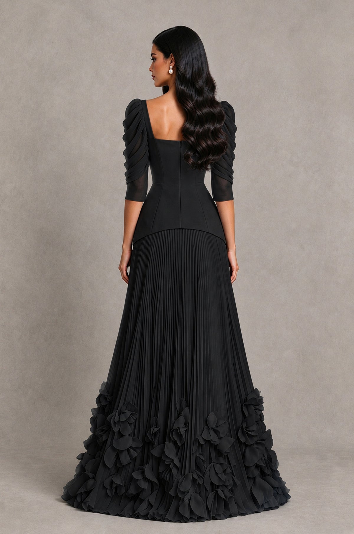 Black square-back evening dress with pleated skirt and petal-like floral ruffles, rear view