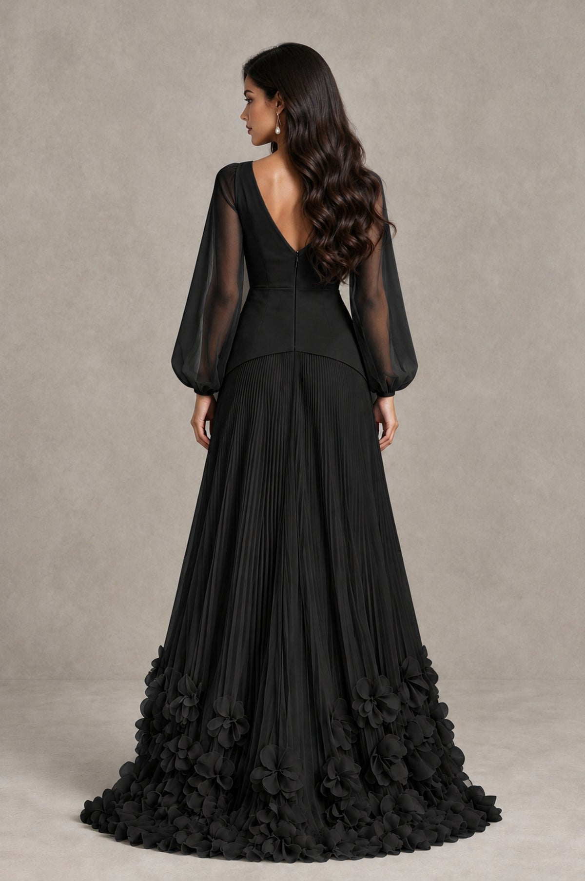 Rear view of black V-back evening dress with sheer bishop sleeves, pleated skirt and floral hem