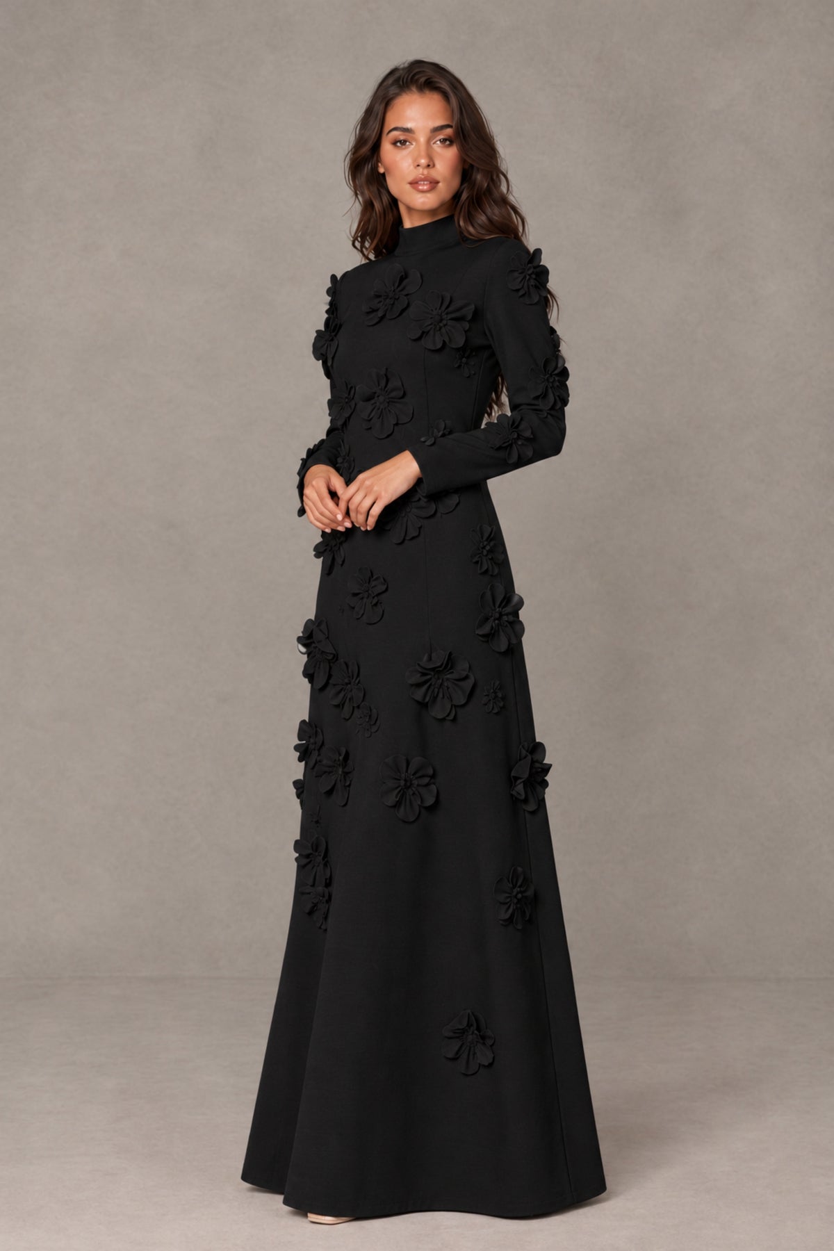 Three-quarter view of BOLODOO black floral applique formal gown showing defined waist and flared maxi skirt
