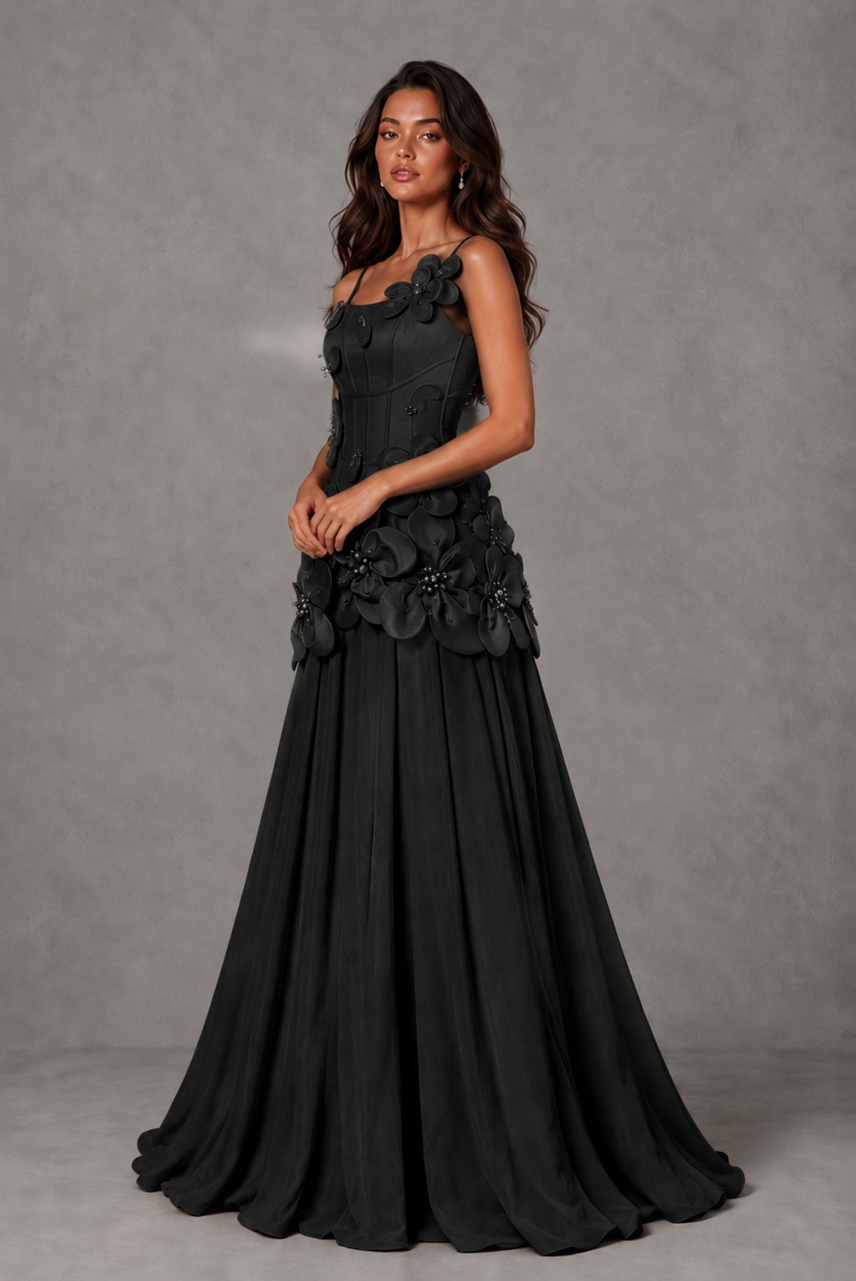 Front view of black 3D floral appliqué gown showing flowing floor-length A-line skirt
