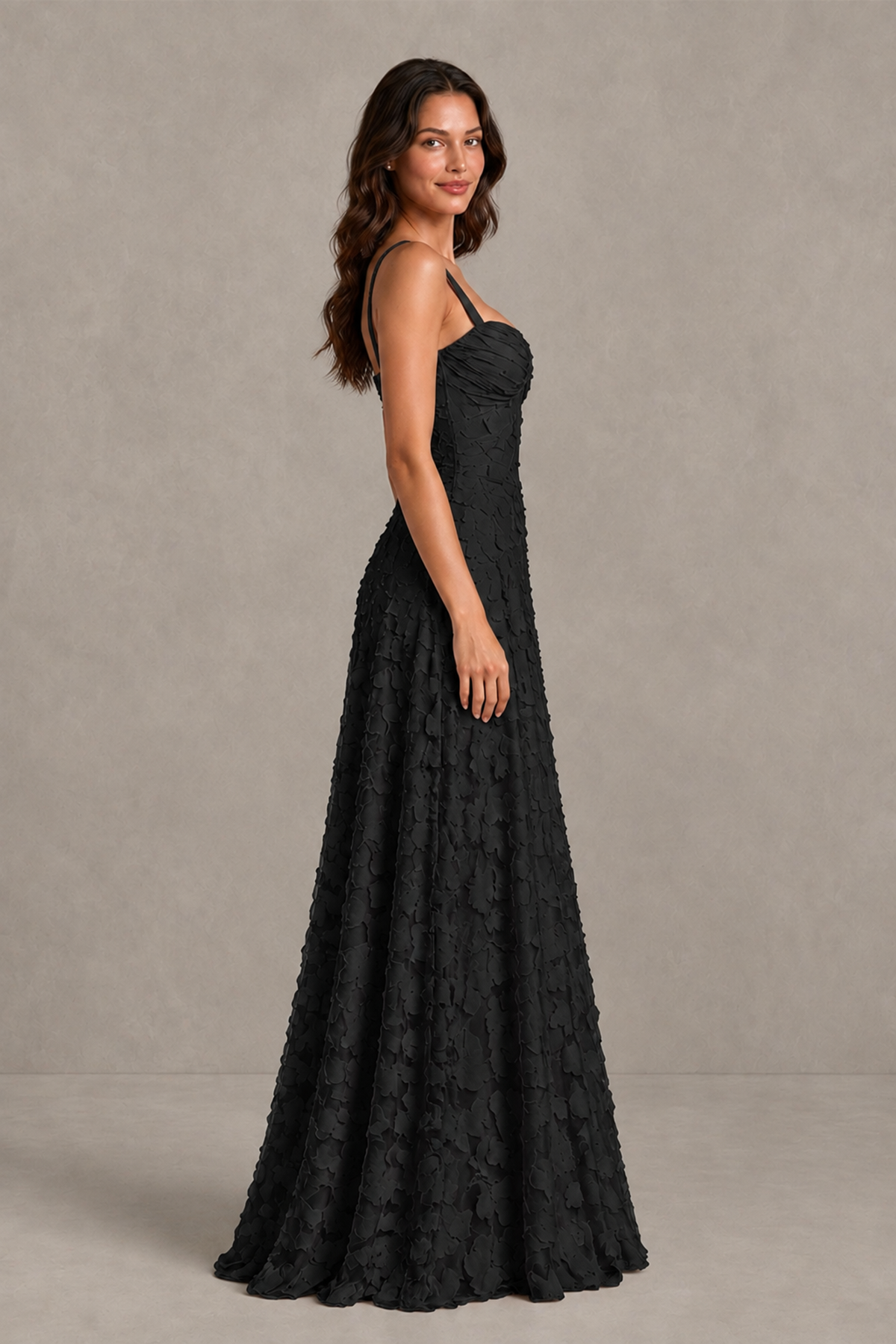 Side view of BOLODOO black floral-textured A-line gown showing fitted waist and flared floor-length skirt