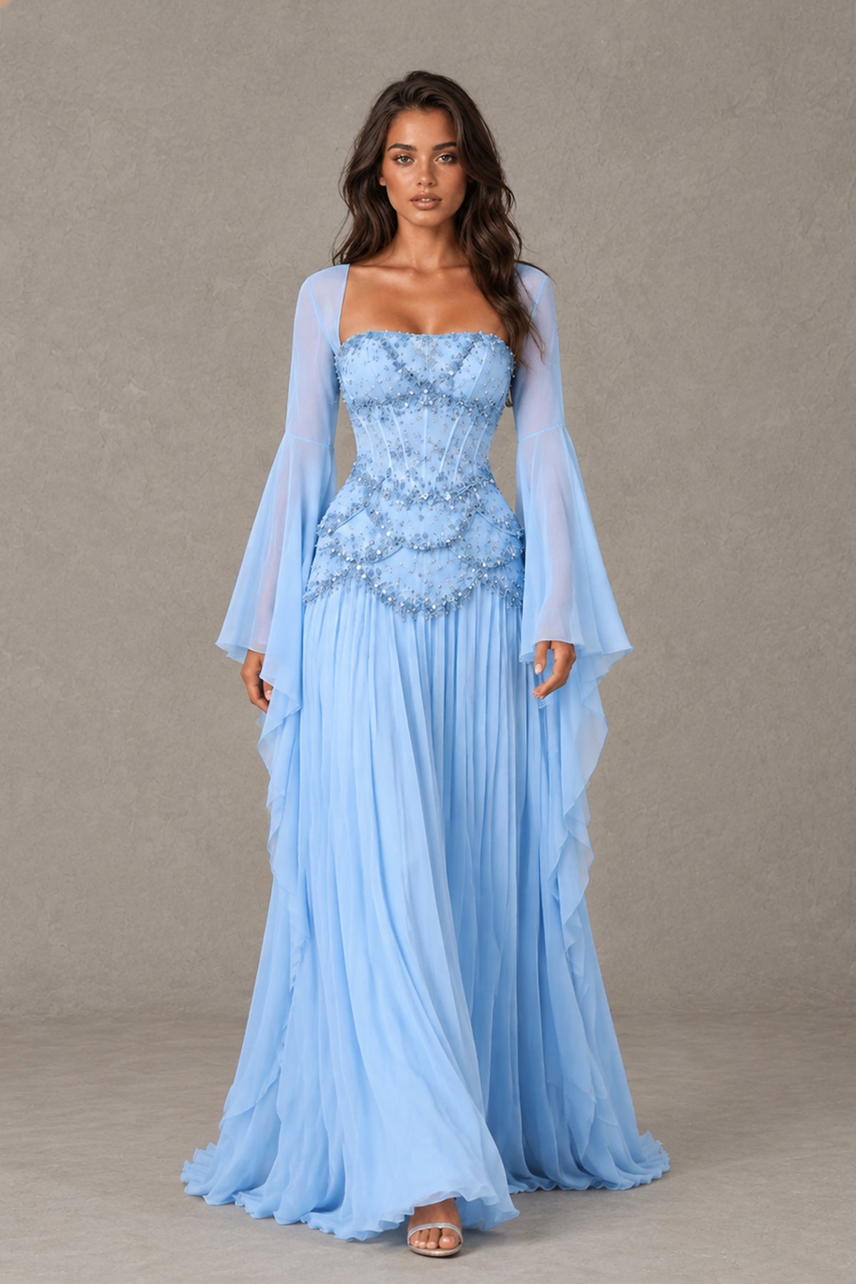 Walking front view of BOLODOO light blue floor-length gown with flowing skirt and bell sleeves