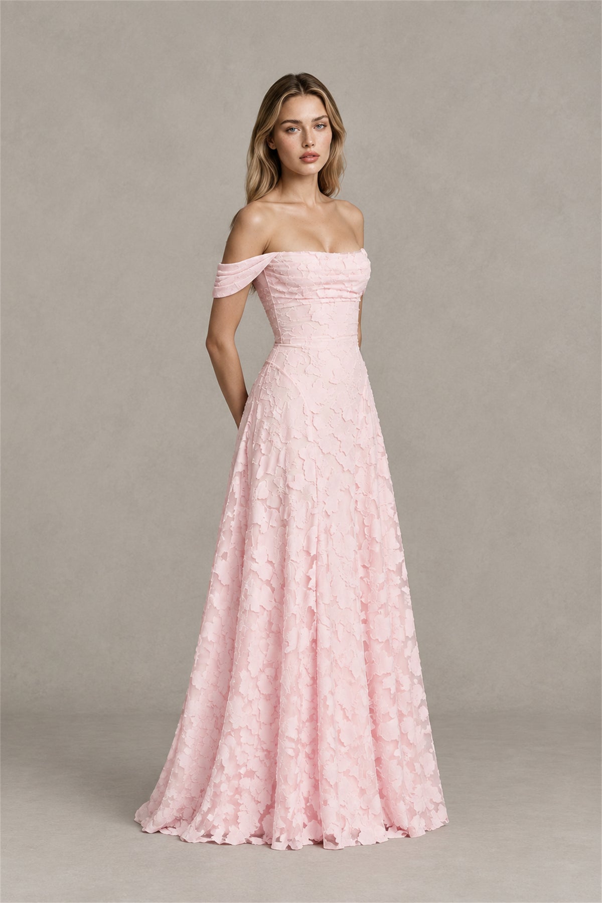 Three quarter view of blush pink off shoulder A-line occasion dress