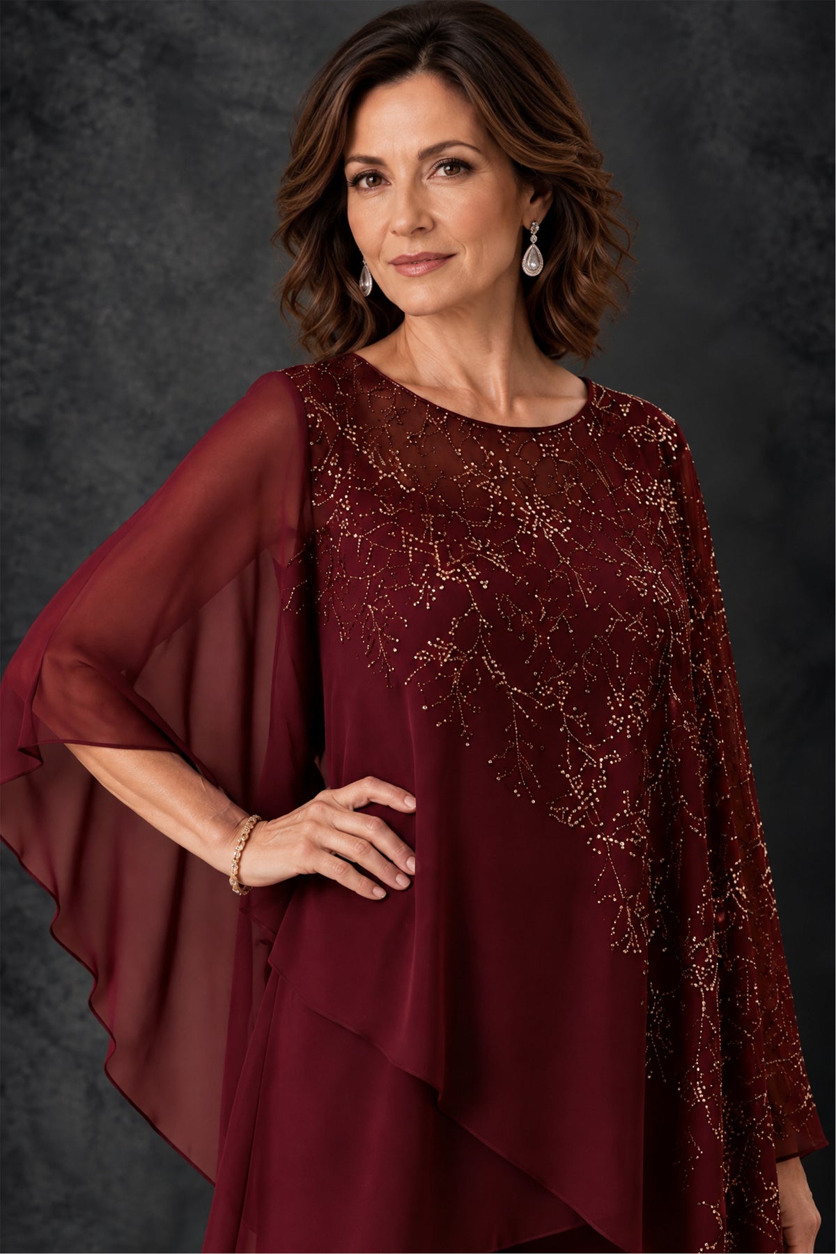 Close-up of sparkling botanical embellishment and sheer cape sleeve on BOLODOO burgundy pant suit