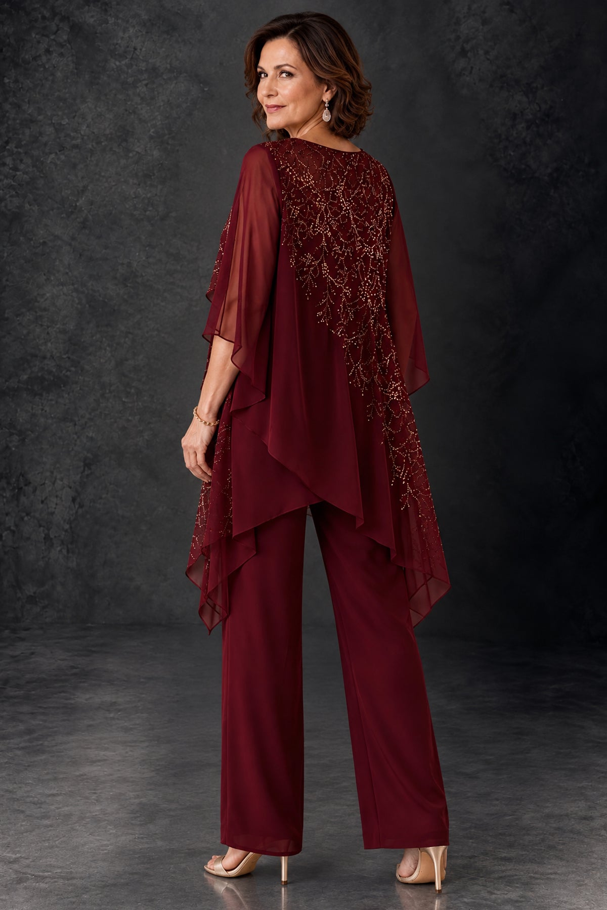 Back view of BOLODOO burgundy pant suit with covered back and embellished asymmetric cape