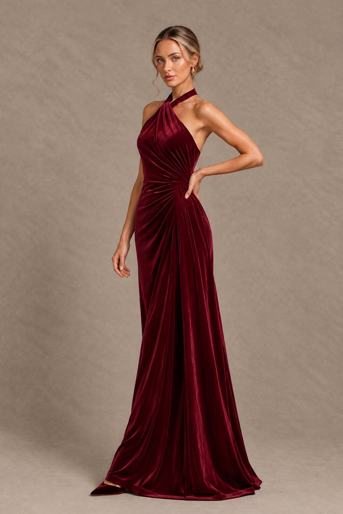 Burgundy floor-length halter gown with fitted silhouette and draped skirt, angled view