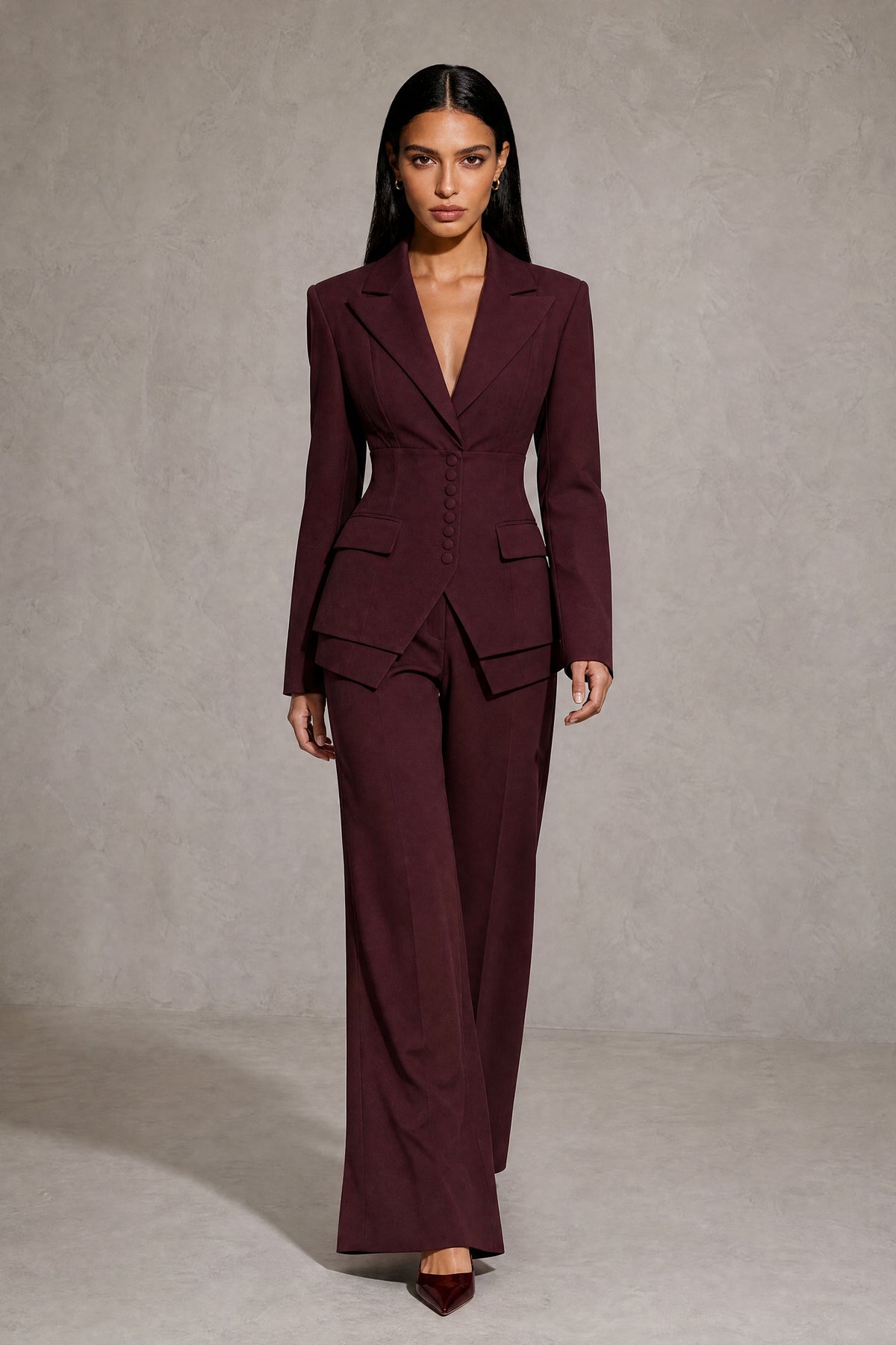 Model walking in burgundy wide leg pant suit with peak lapel blazer, full length front view