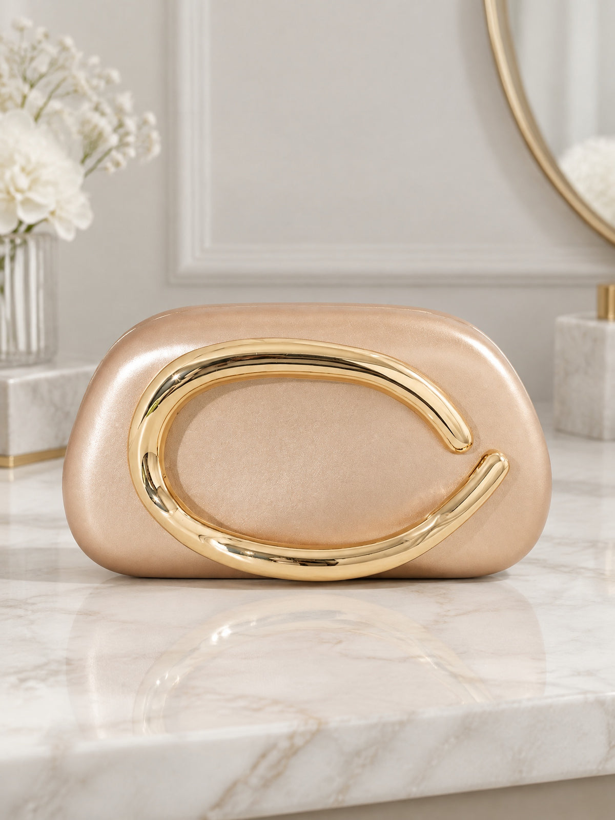 BOLODOO champagne evening clutch front view with sculptural gold-tone handle