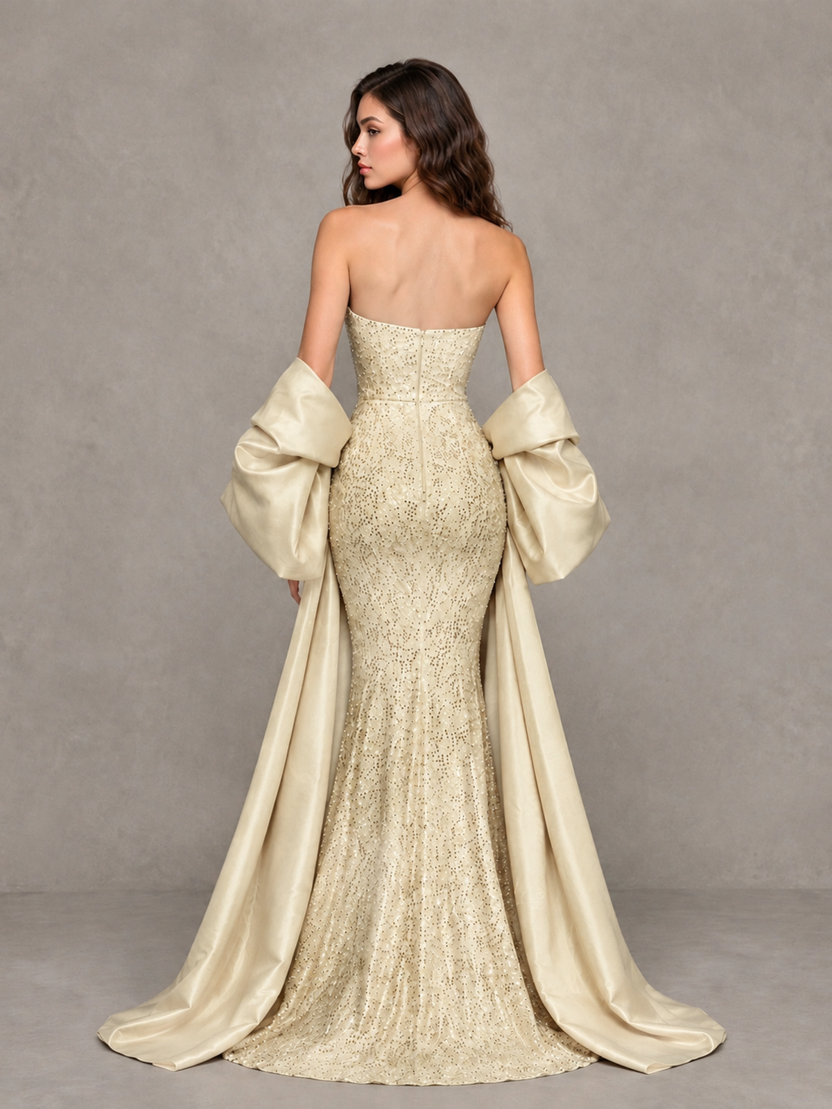Champagne strapless mermaid gown with exposed upper back and long satin-look side drapes, back view