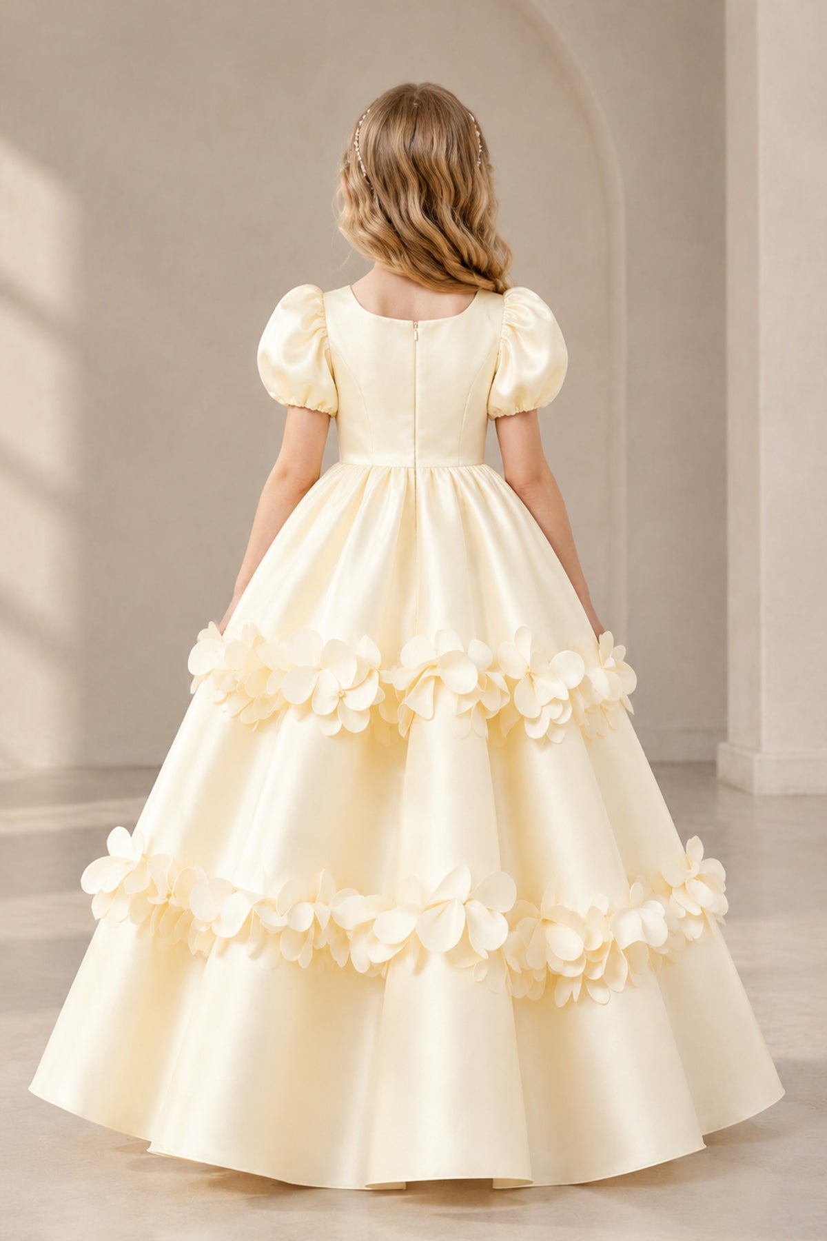Side view of a girl in a champagne satin flower girl gown with puff sleeves