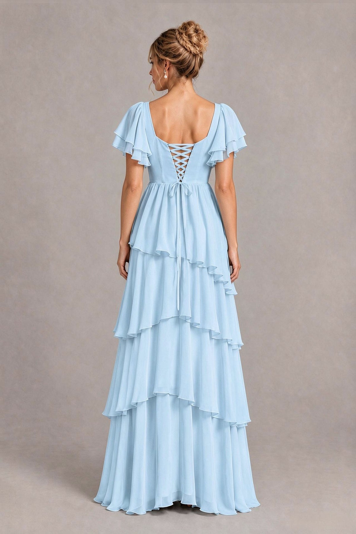 Back view of a light blue chiffon bridesmaid dress with lace-up back and tiered ruffle maxi skirt