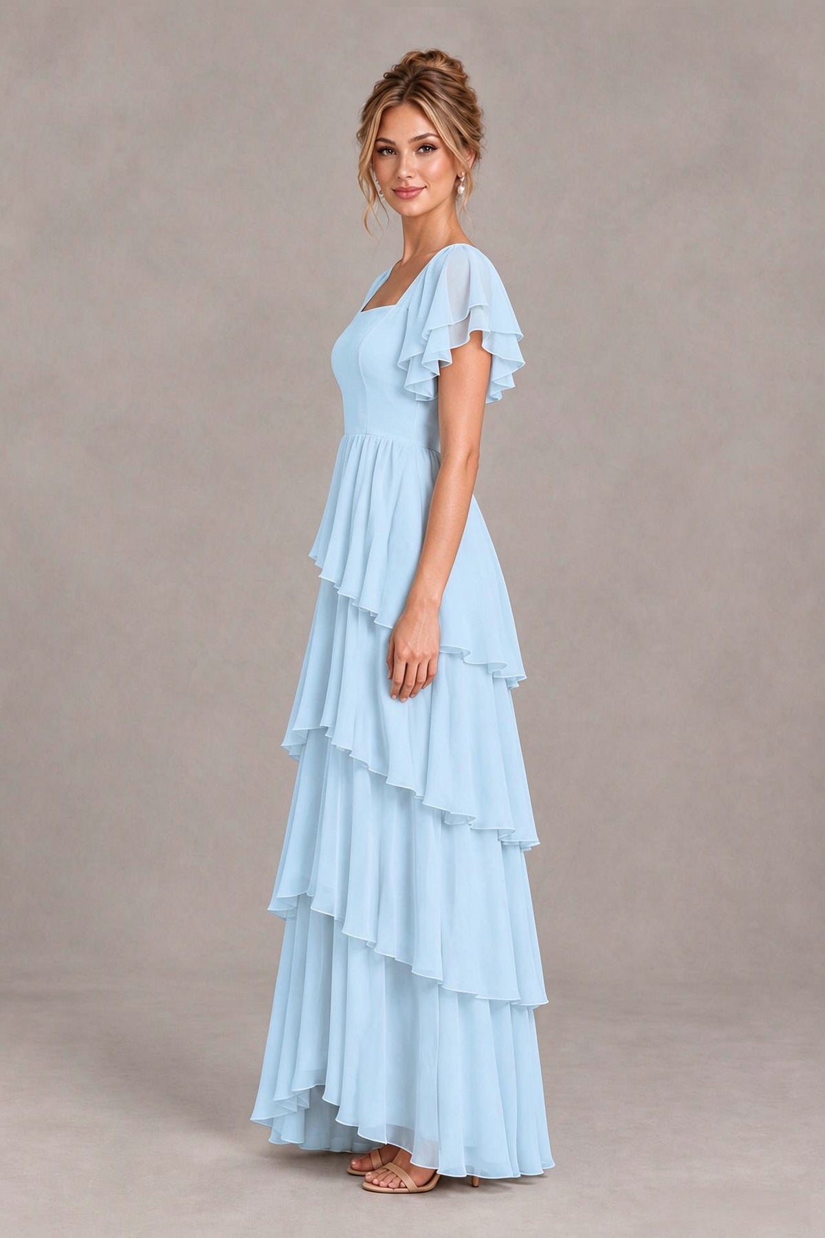 Side view of a light blue square neck chiffon bridesmaid dress with flutter sleeves and tiered floor length skirt