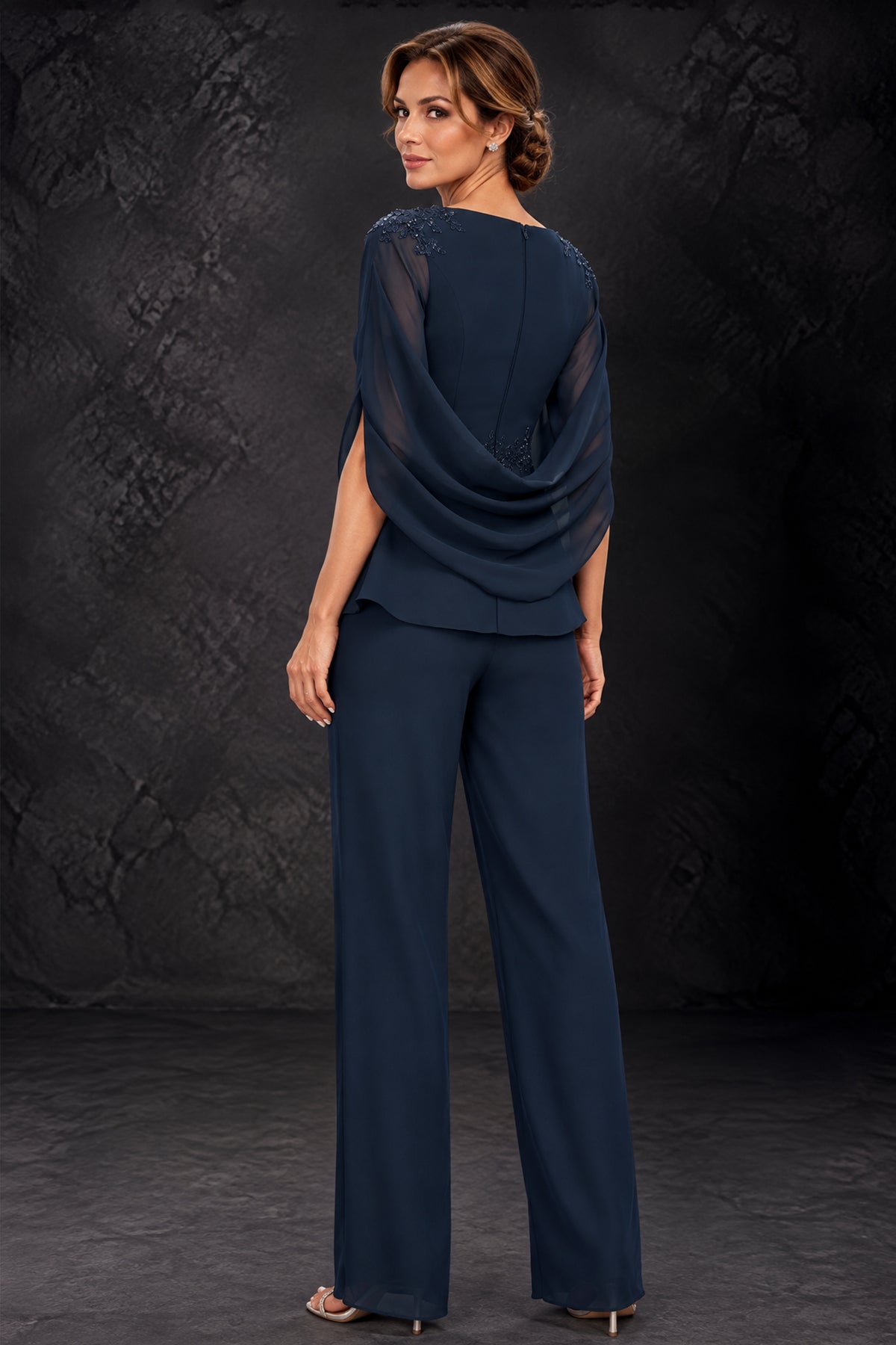 Back view of BOLODOO navy blue pantsuit with covered back, draped cape and wide-leg trousers