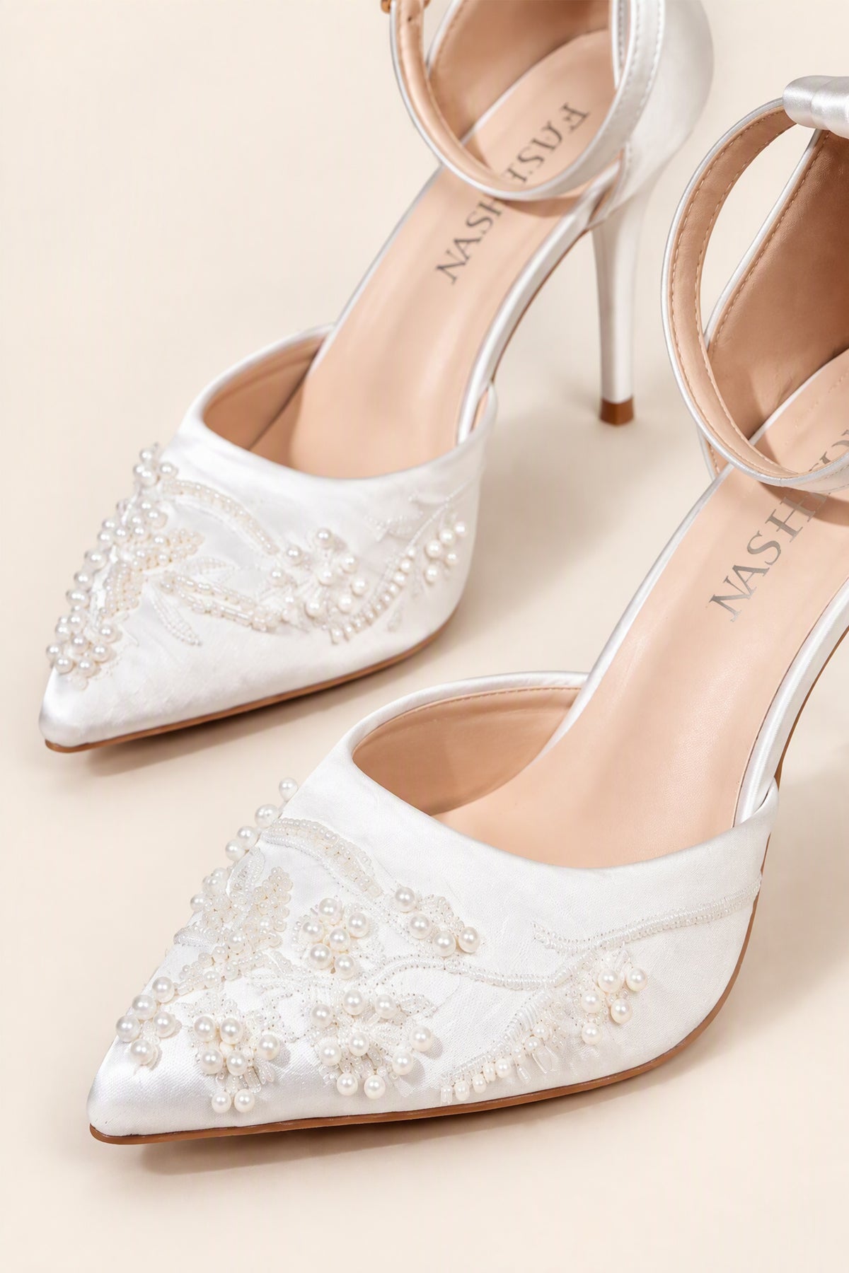 Close-up of pearl-like bead embellishments on BOLODOO white pointed-toe occasion shoes