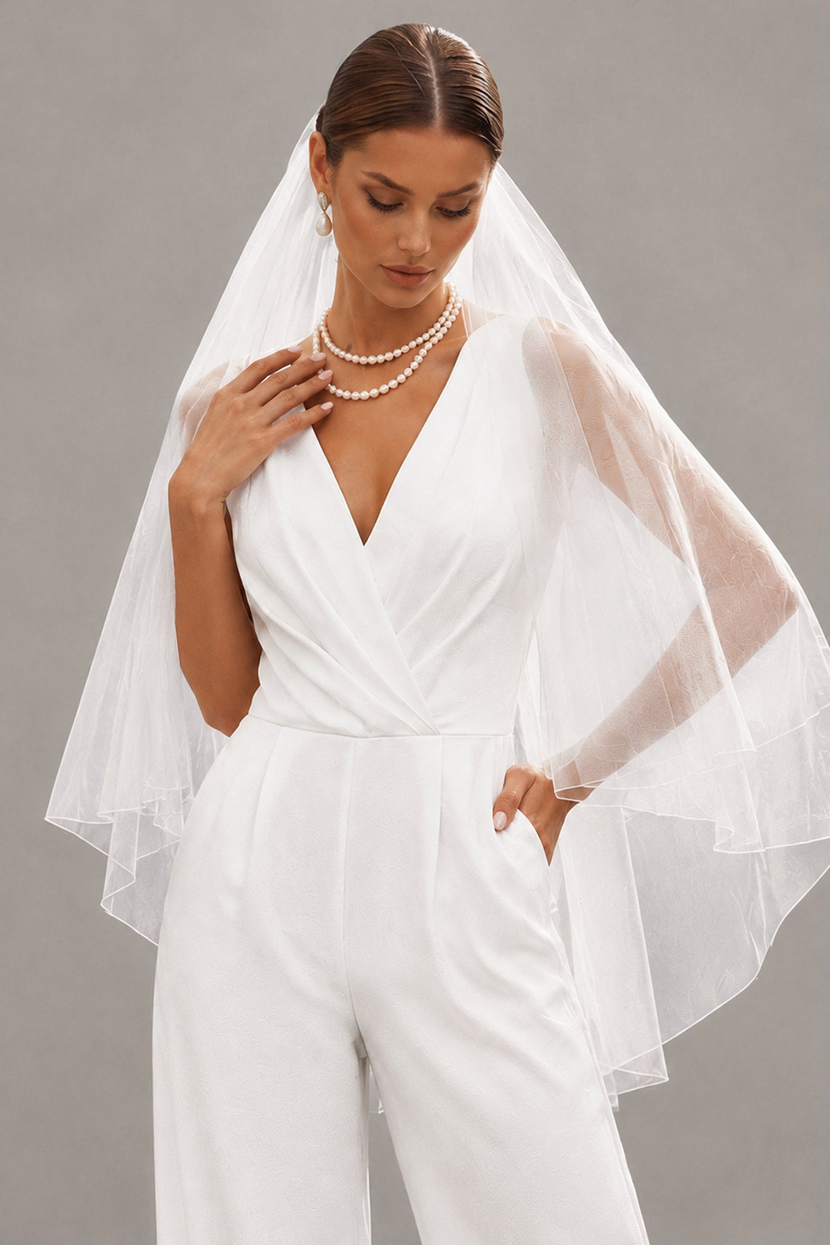 Close-up of BOLODOO white bridal jumpsuit V-neck bodice, waist and pocket