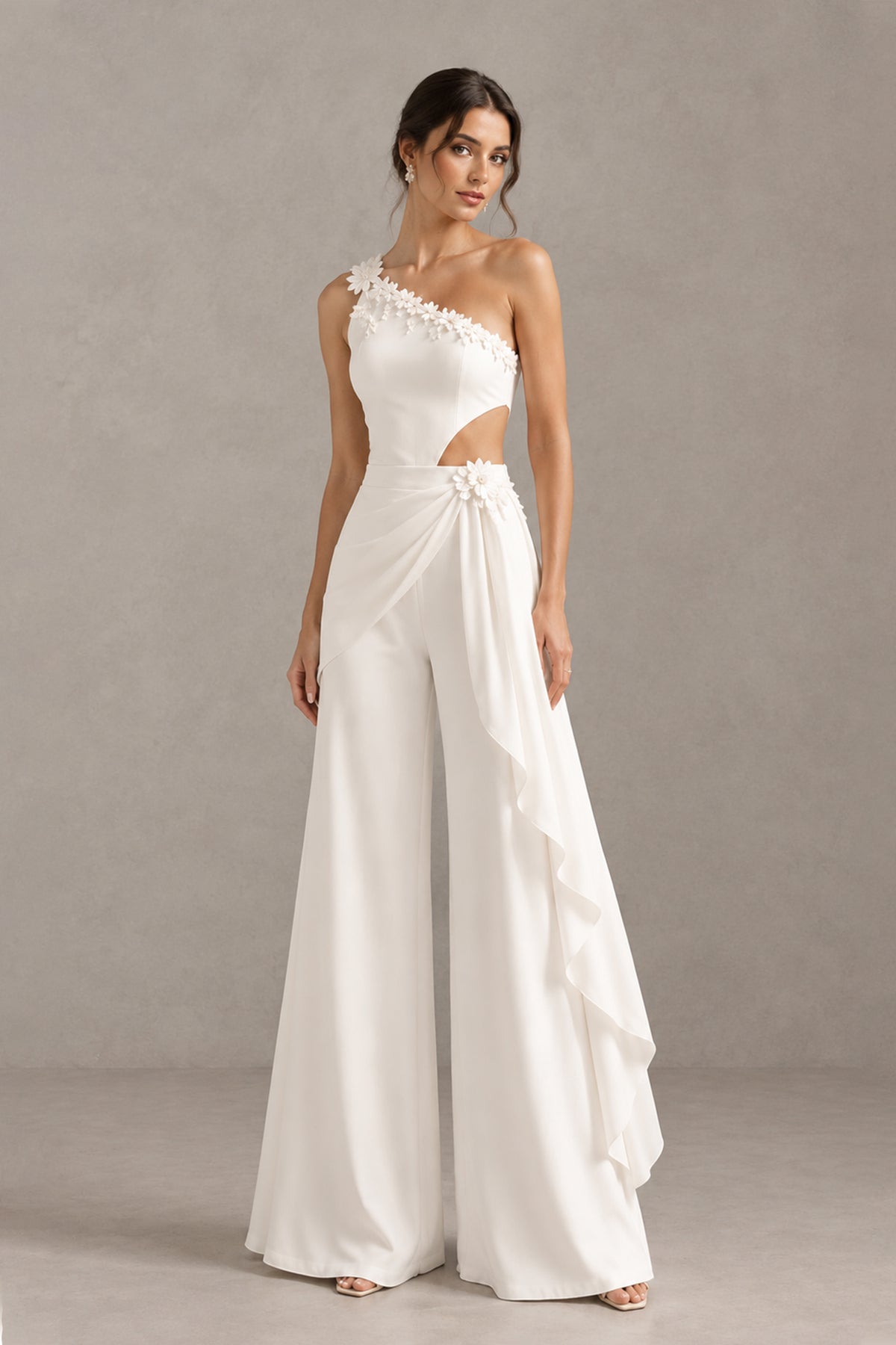 White bridal jumpsuit angled front view showing waist cutout and cascading side ruffle