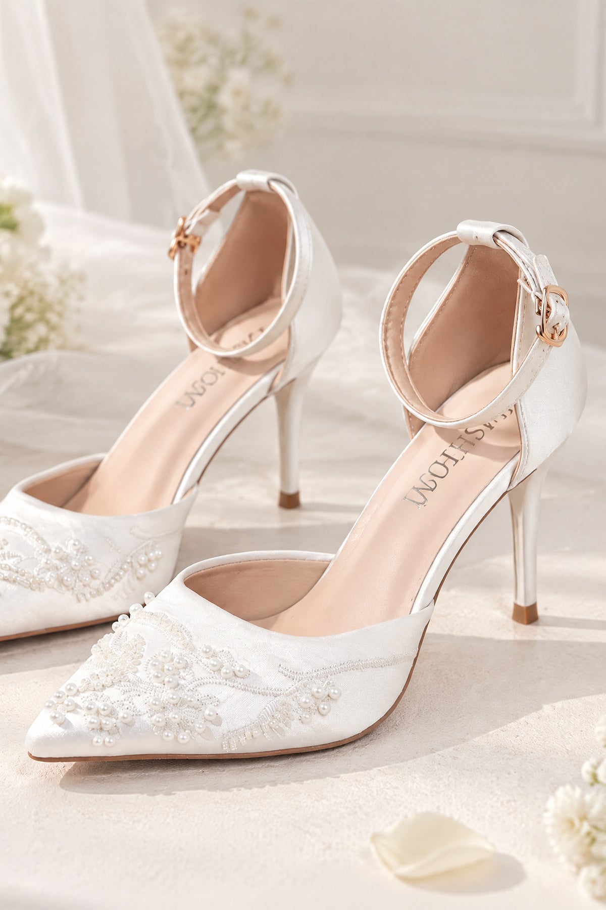 Side detail of BOLODOO white bridal heels showing pointed toe, bead embellishments and buckle ankle strap