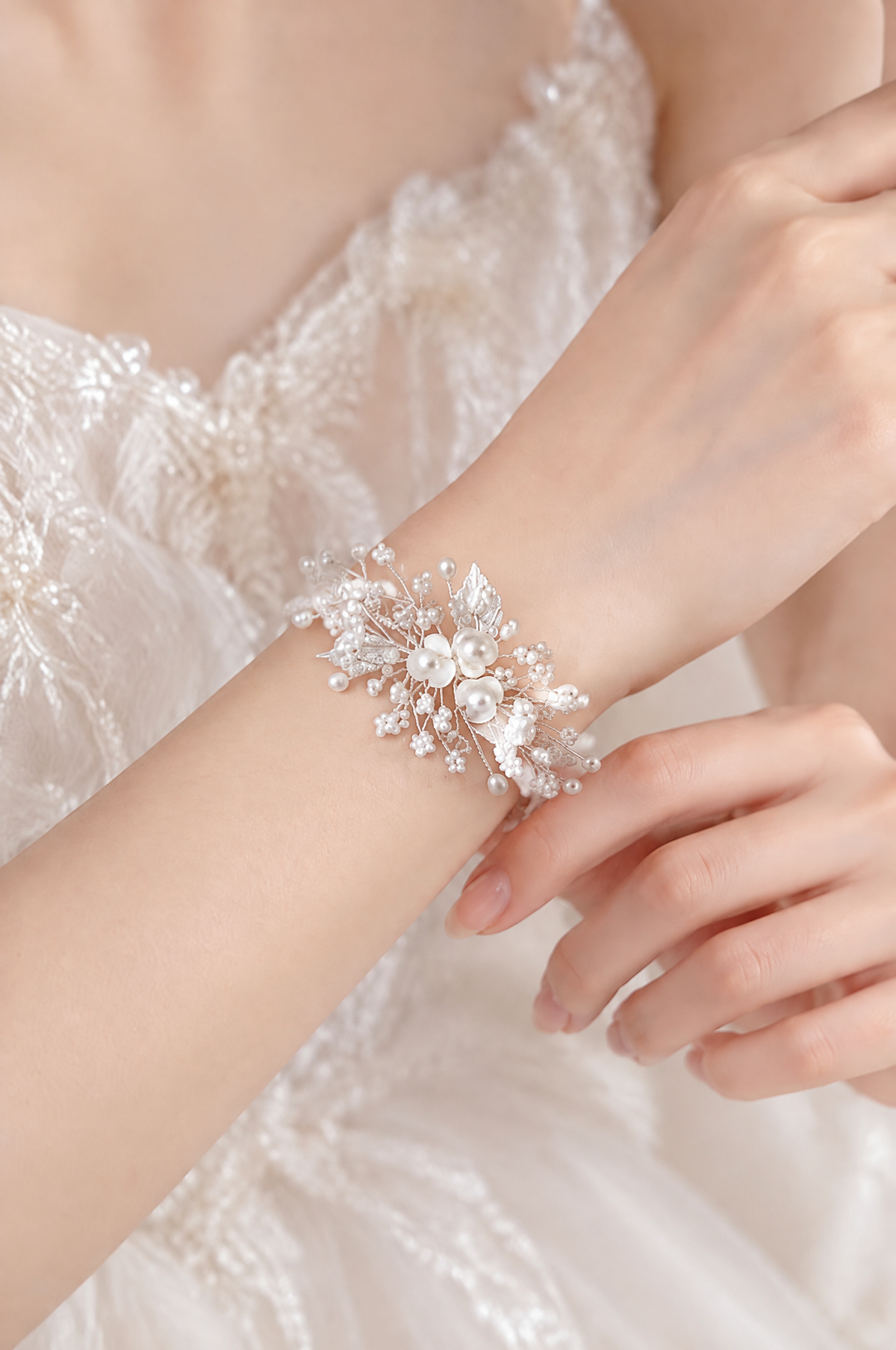 BOLODOO white floral pearl-look bridal bracelet worn on the wrist with a wedding dress