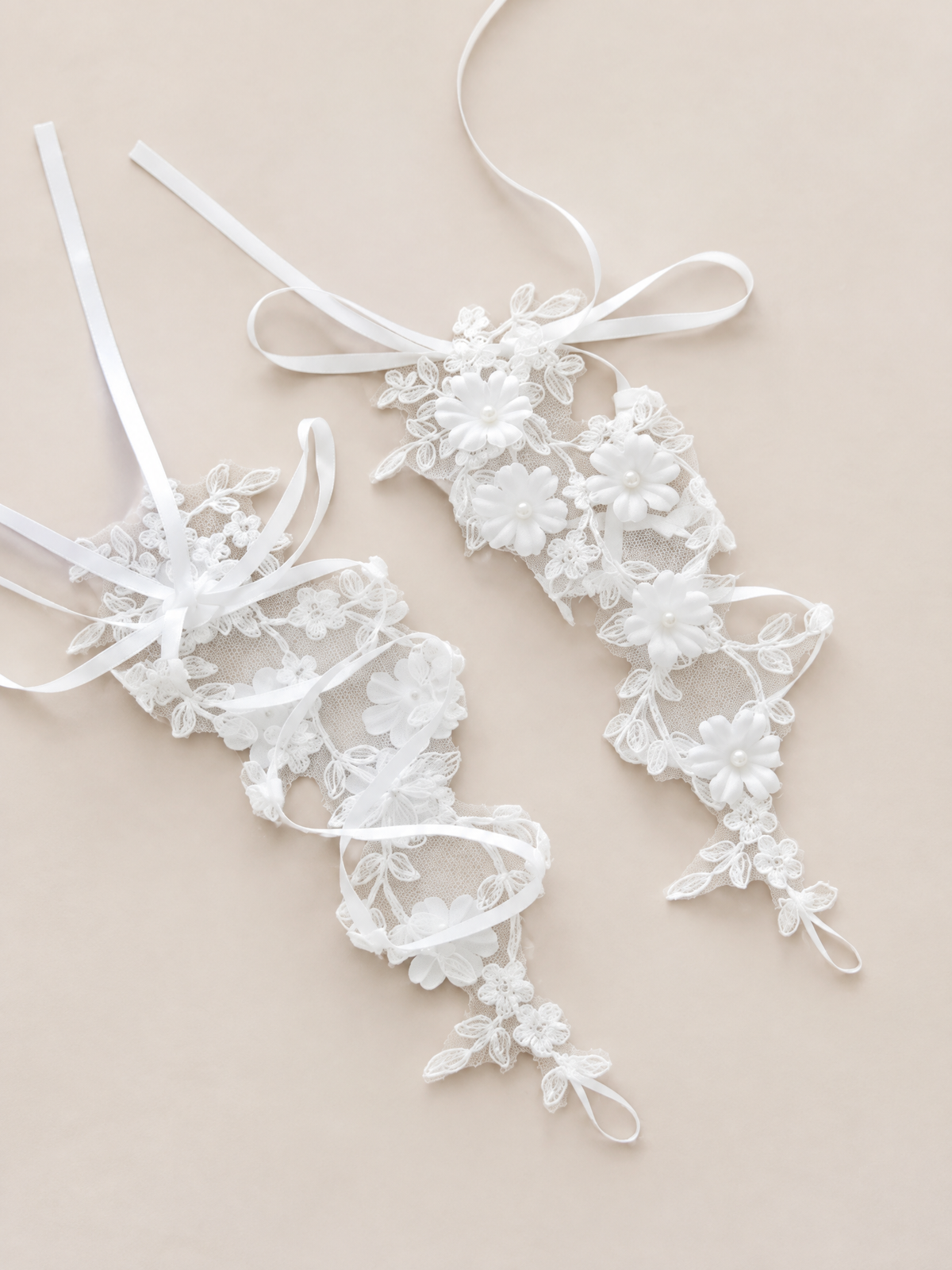 Pair of BOLODOO XCD023 white floral bridal gloves laid flat showing sheer mesh and ribbon ties