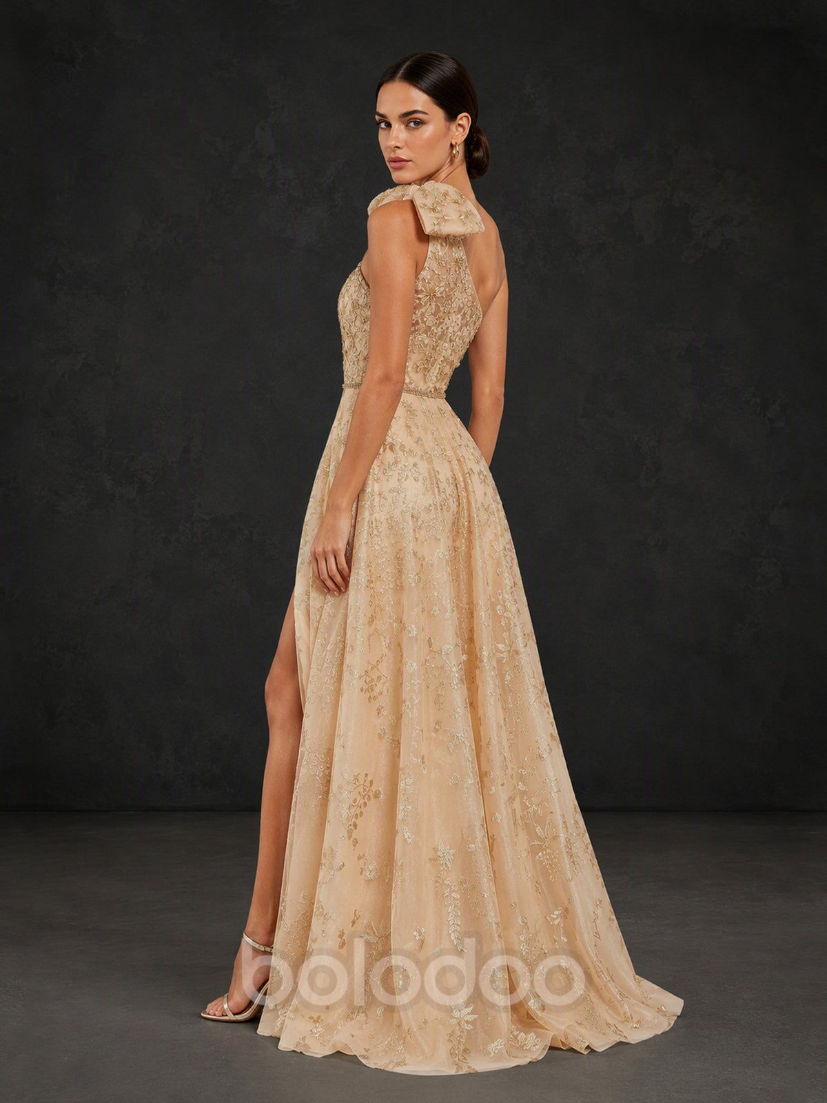 BOLODOO BX0016 champagne gold one-shoulder gown - back three-quarter view showing open back, one-shoulder bow strap and sweeping glitter lace A-line train with front slit | BOLODOO watermark