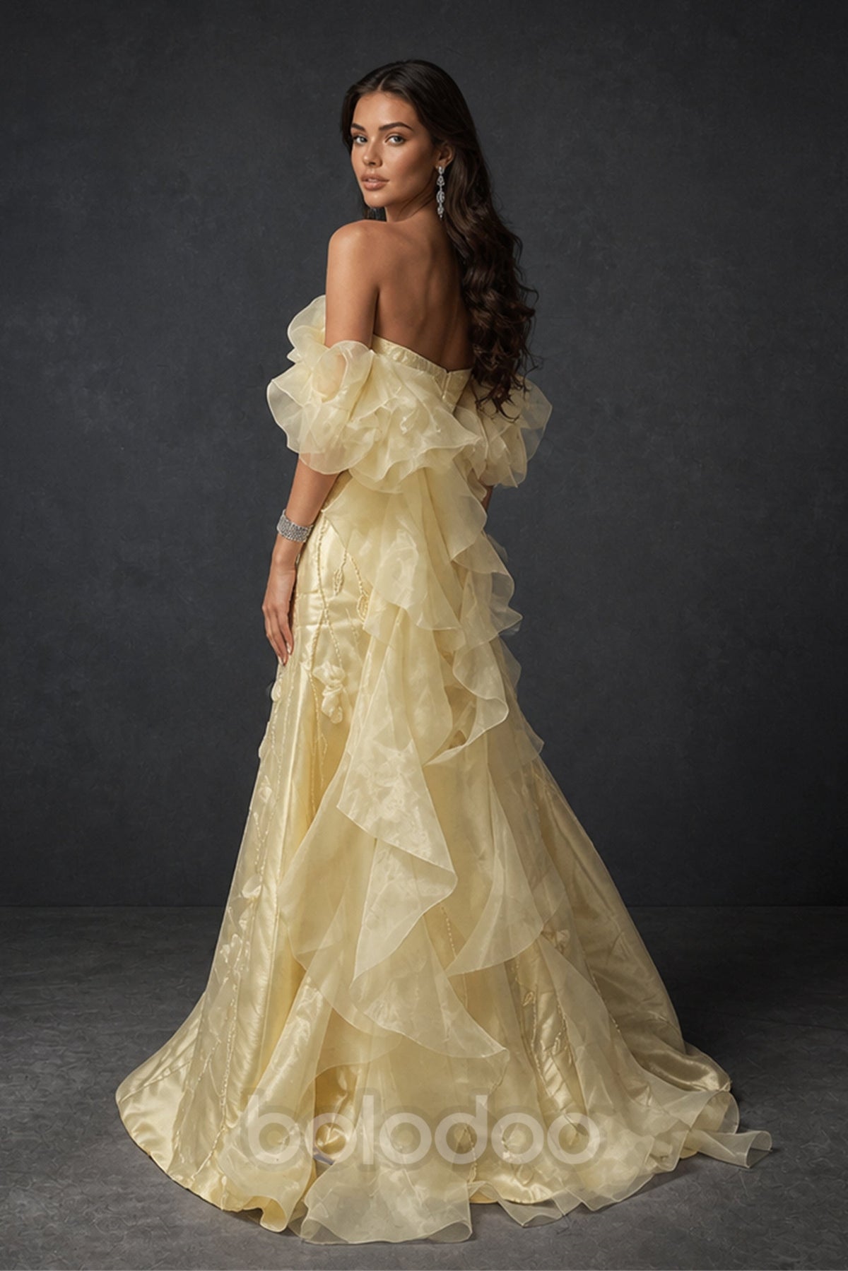 BOLODOO BX0018 butter yellow ruffle organza gown - back three-quarter view showing open back, off-shoulder puff sleeves and full cascading organza ruffle A-line skirt with sweep train | BOLODOO watermark